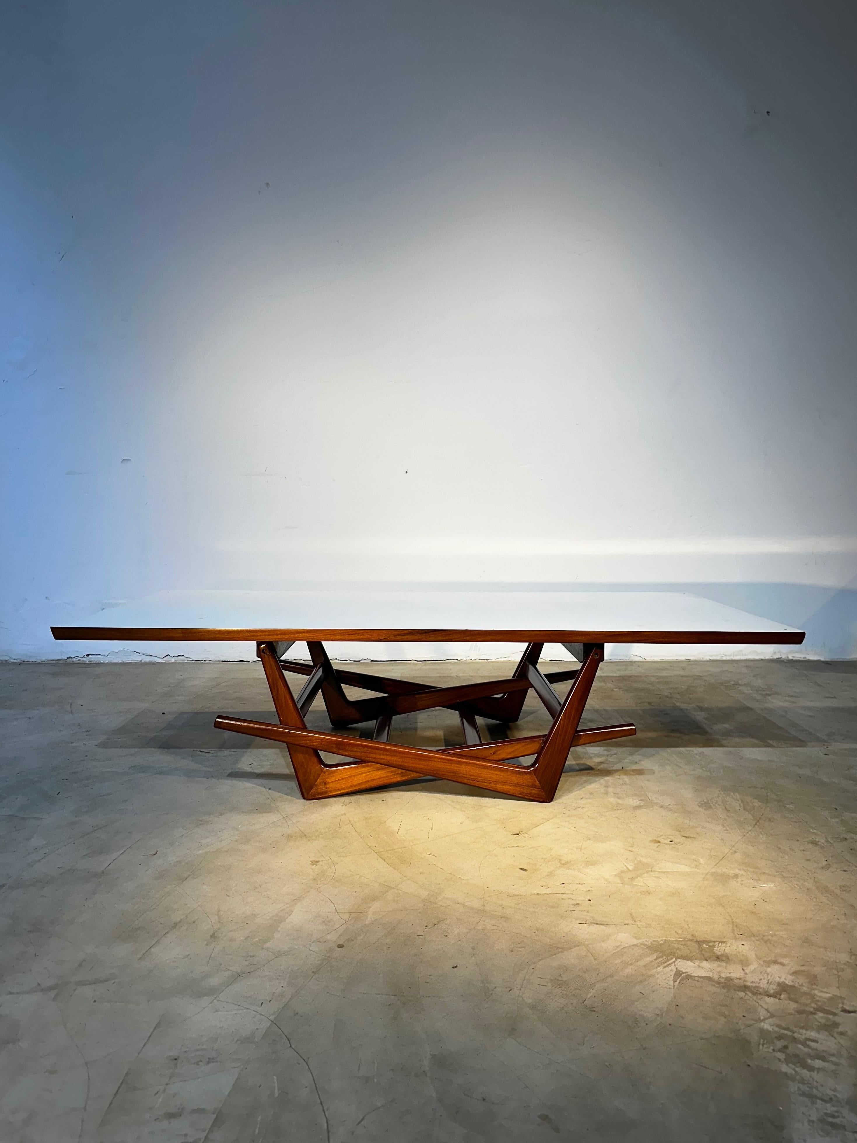Beautiful folding center table by Martin Eisler, one of the founders of the company Forma, an important and influential name of Brazilian design. With creatively designed feet in caviúna wood (a Brazilian wood also known as 