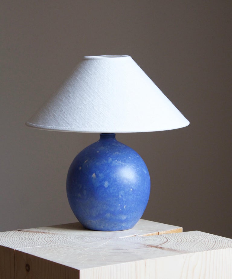 A table lamp designed and produced by Martin Flodén, in his studio, Arvika, Sweden, c. 1940-1950s. In stoneware with a highly artistic blue glaze.

Stated dimensions exclude lampshade. Height includes socket. Sold without lampshade.

Glaze features