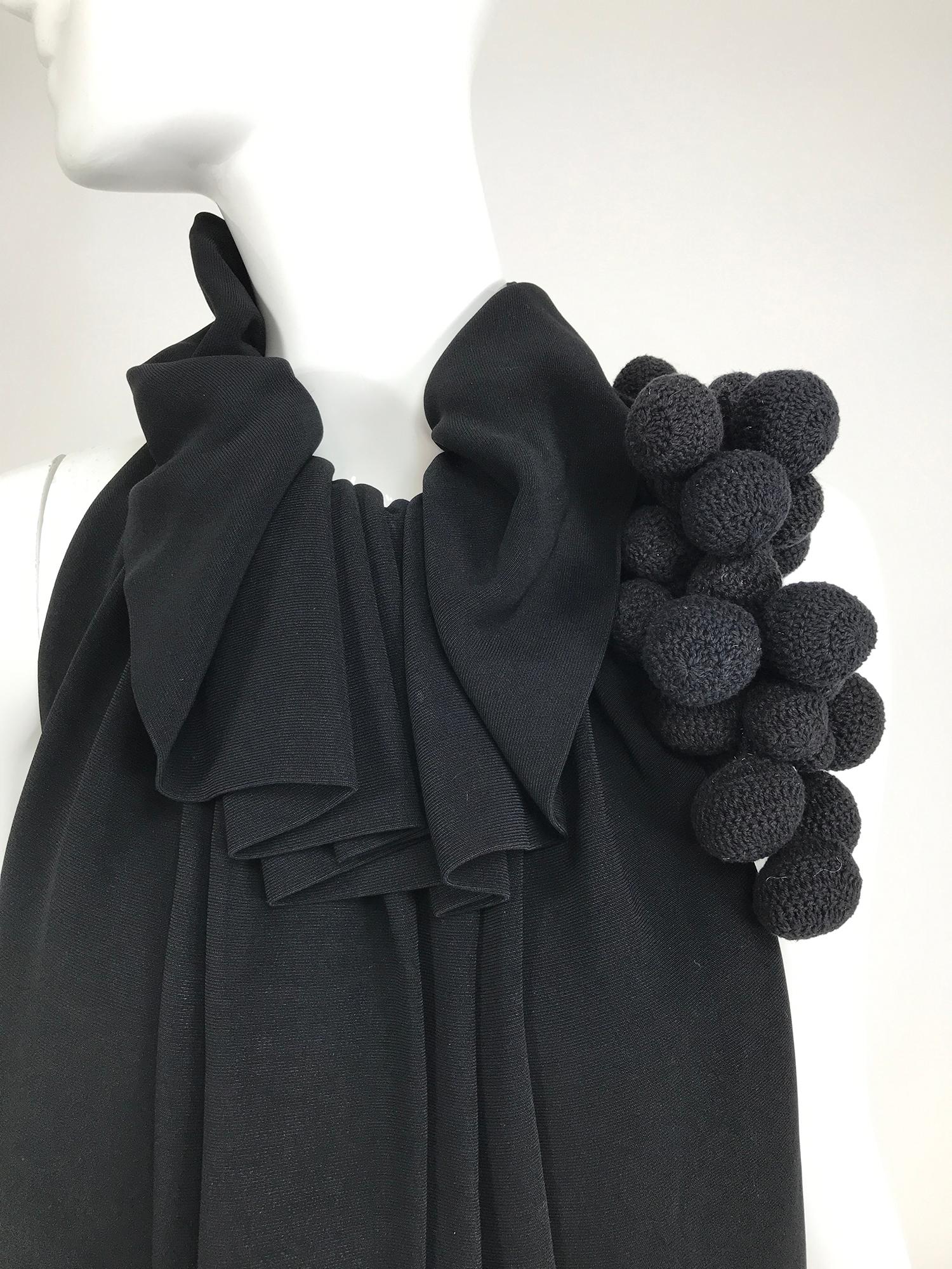 Martin Grant black sleeveless gathered tunic top with a neck corsage of crochet black balls. Racer neck top is gathered at the neck with a ruffle, open gathers fall full to the hem. The top closes at the neck back with hook & eyes.  Unlined, a cute