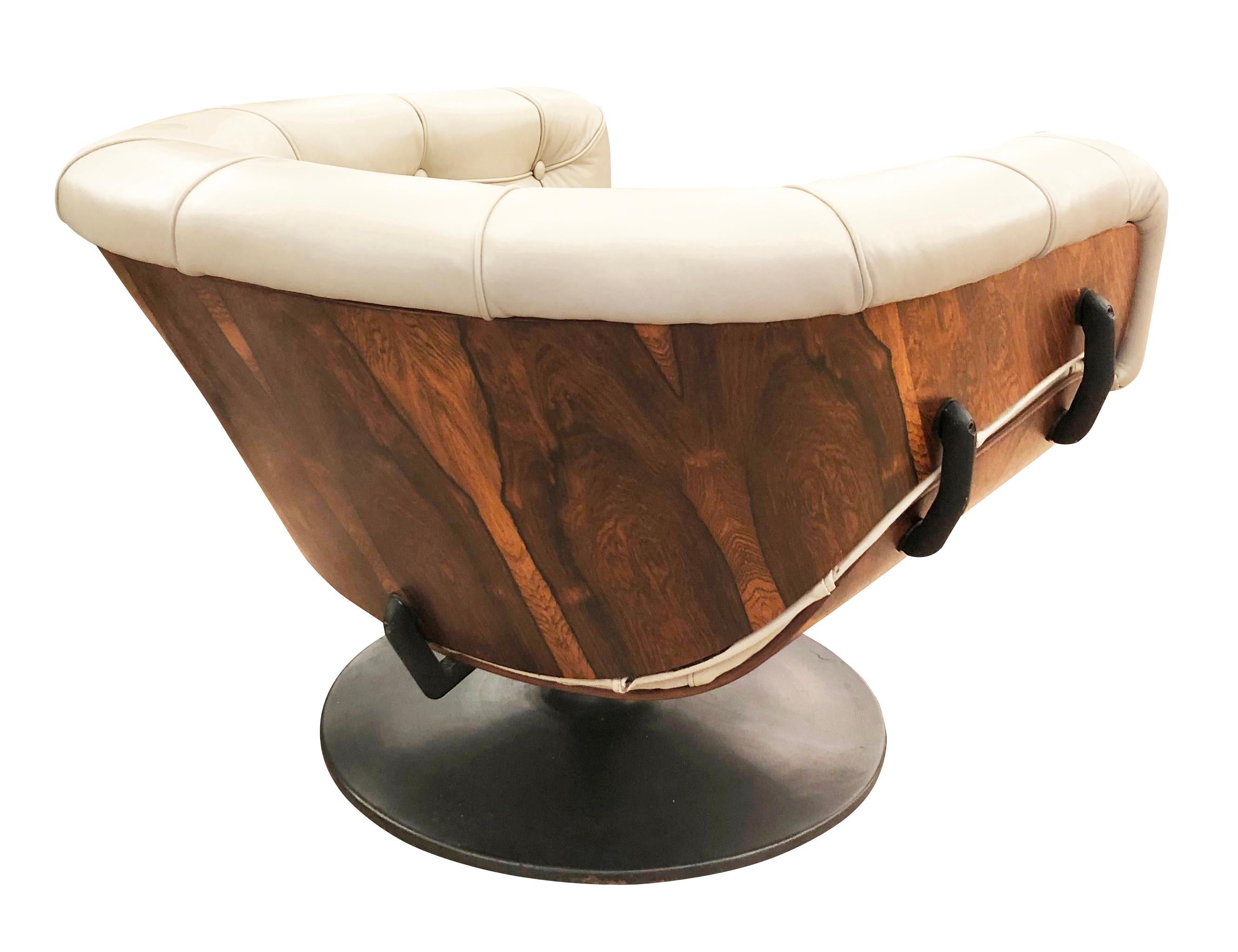 Iconic lounge chair designed by English designer, Martin Grierson, for Italian seating manufacturer, Artflex. This piece was ahead of its time with a bold modern look defined by its rosewood shell and tufted leather. The swiveling pedestal is