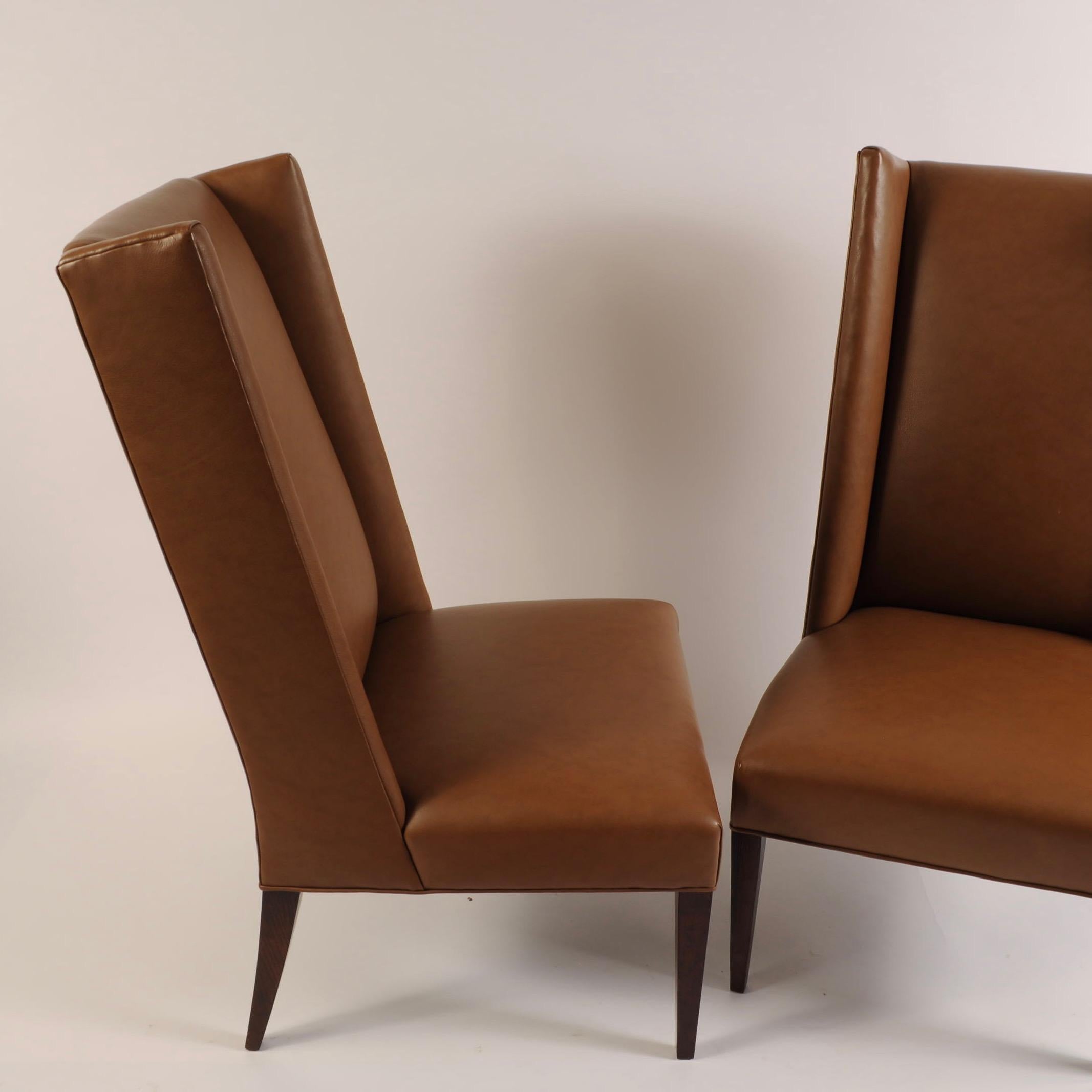 Two glove brown leather-like Naugahyde chairs by North Carolina furniture maker Hickory Chair. Legs are dark walnut.