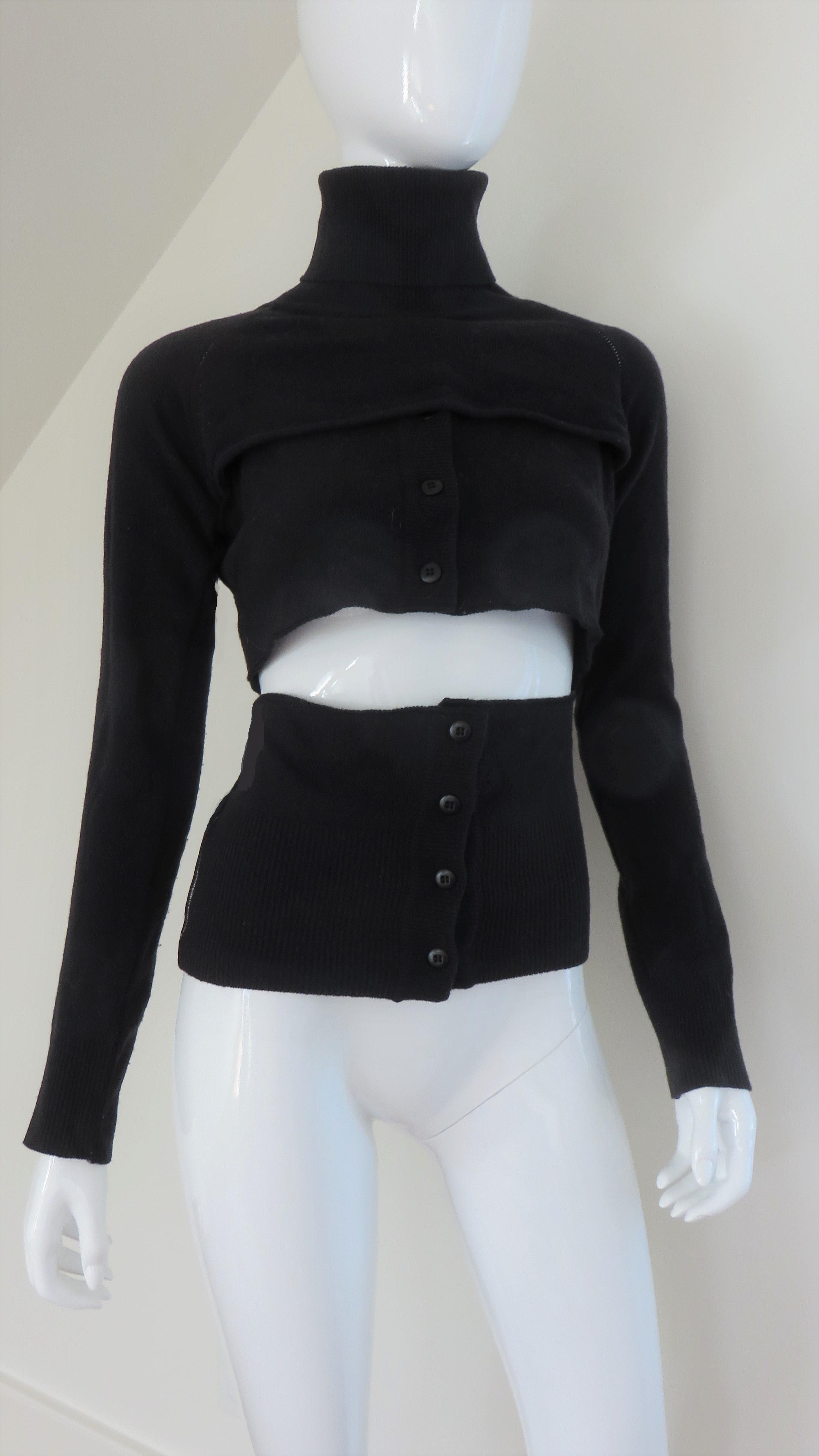 A fabulous black wool knit 4 piece sweater set from Martin Margiela. It consists of a crop long sleeve turtleneck, a long sleeve shrug, a crop sleeveless vest and a wide hip band.  All can be configured in different ways or worn separately.  
Marked