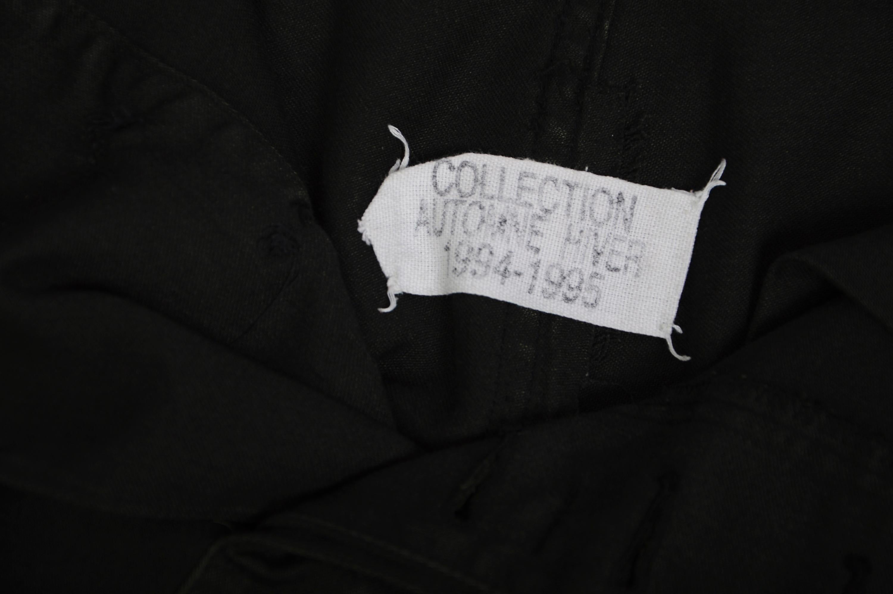 A/I 1994 Maison Martin Margiela Gonna cargo artigianale con surplus militare. Maxi gonna cargo nera ricavata da pantaloni cargo degli anni '60, design destrutturato con tasche stile cargo nella parte inferiore dei fianchi e bordi grezzi. Chiusura