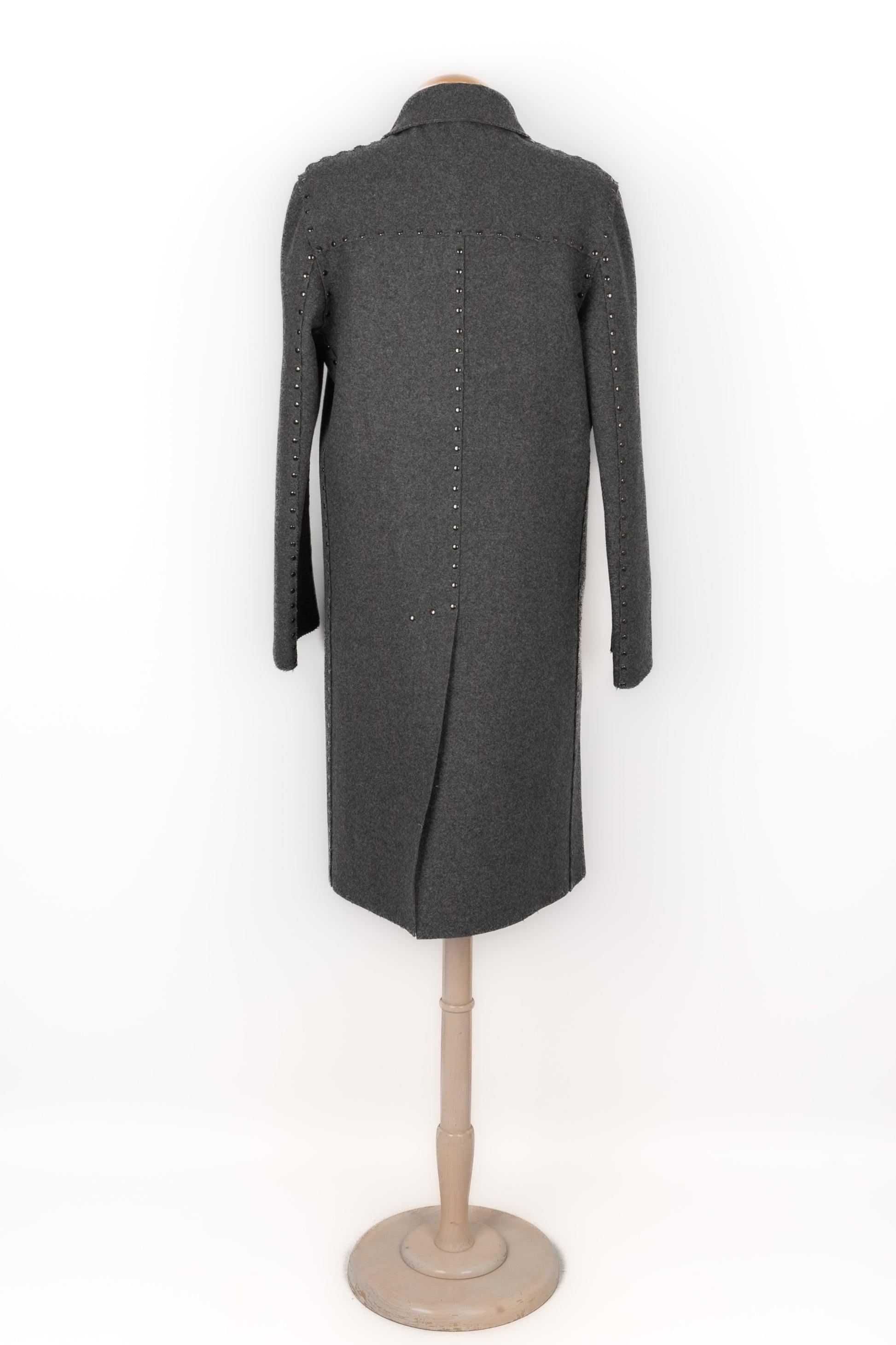 Martin Margiela - Abrigo largo de lana gris con tachuelas metálicas. Faltan las etiquetas de talla y composición, se ajusta a una 46FR.

Más información:
Estado: Muy buen estado
Dimensiones: Anchura de los hombros: 46 cm - Longitud de las mangas: 65