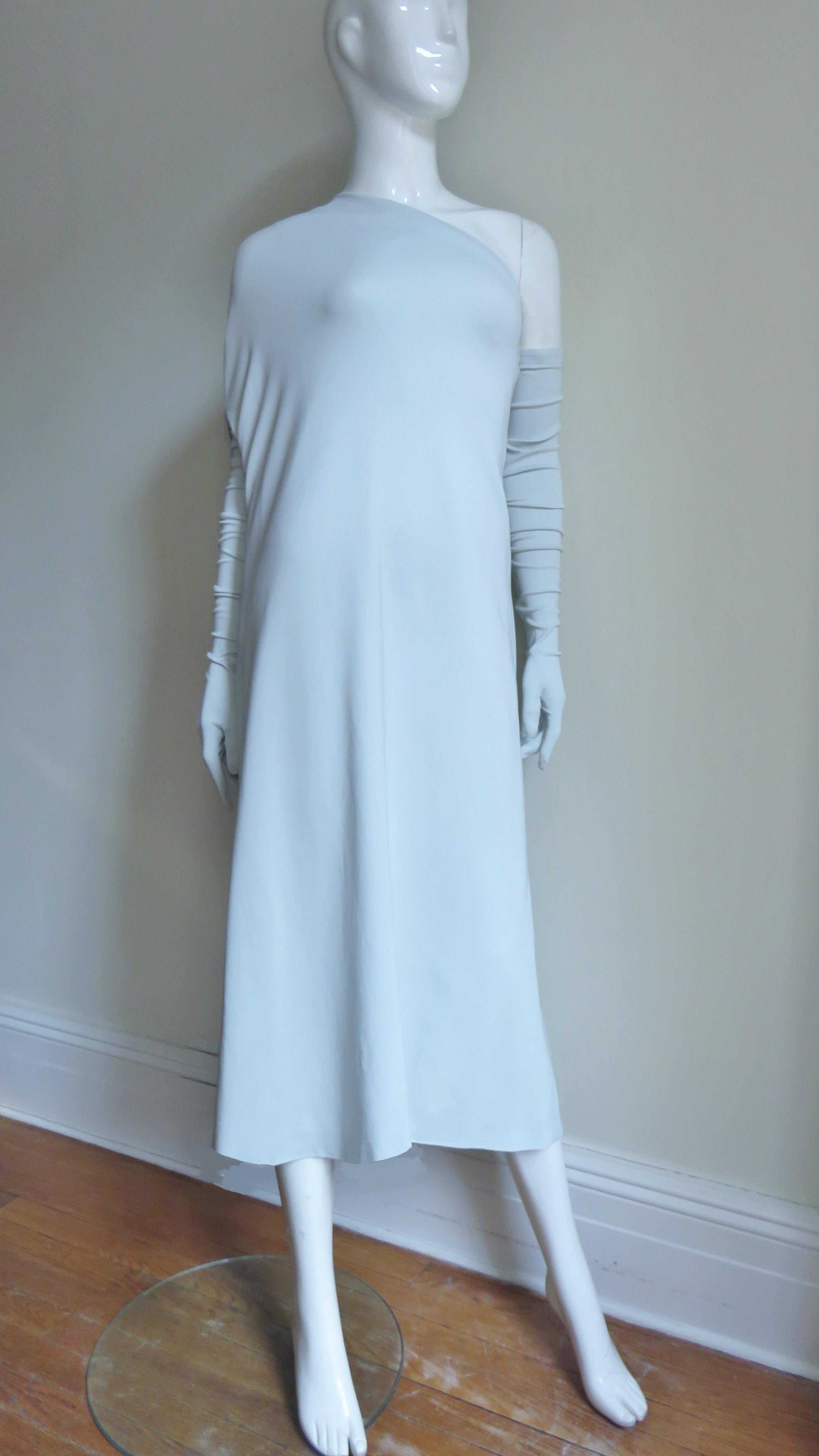 A fabulous dramatic pale mint one shoulder jersey dress from Martin Margiela with matching long gloves.  The dress drapes over one shoulder and has an adjustable zippered opening for the arm to go through which includes a pocket.  The other side