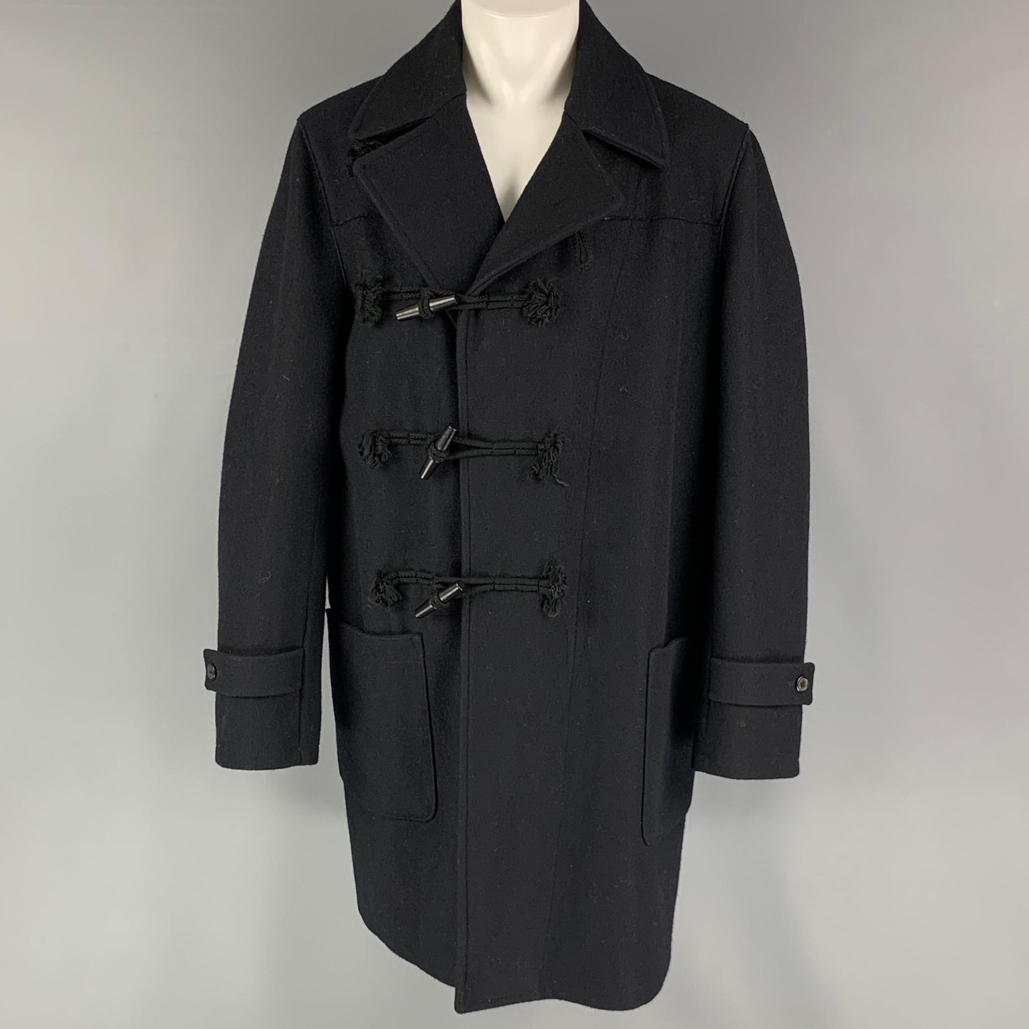 MARTIN MARGIELA REPLICA 70's coat comes in a navy wool fleece material featuring a patch pockets, and a toggle closure. Made in Italy.

Very Good Pre-Owned Condition.
Marked: 14

Measurements:

Shoulder: 19.5 in.
Chest: 50 in.
Sleeve: 28 in.
Length: