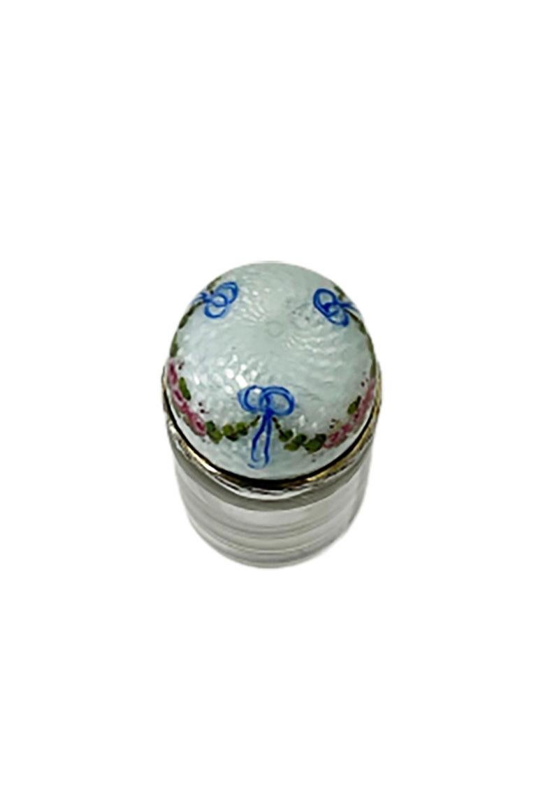 Martin Mayer, Mainz Germany Scent Perfume Bottle, ca 1900

A perfume bottle with an enameled tilt cap with a stopper. The cap is enameled on silver with a scene of a garland of pink roses and blue bows on a white background and leaf pattern rim