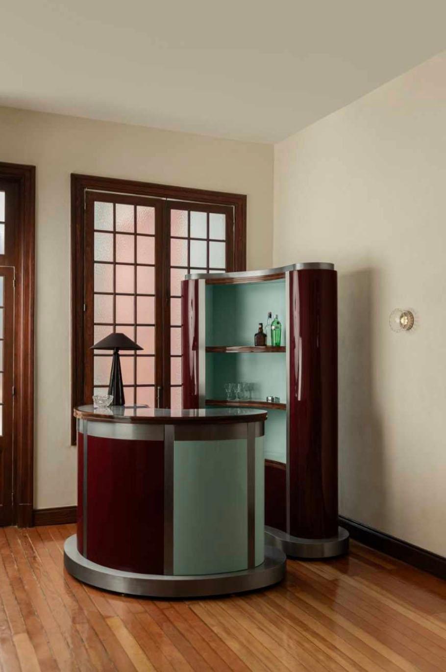 Un bar tête-à-tête inspirado en los años 70, en un viaje a Chicago y en mi hermano, que adoraba las noches con un vaso de whisky.

Fabricado en madera maciza y contrachapado flexible, con un acabado lacado de alto brillo y detalles en madera maciza