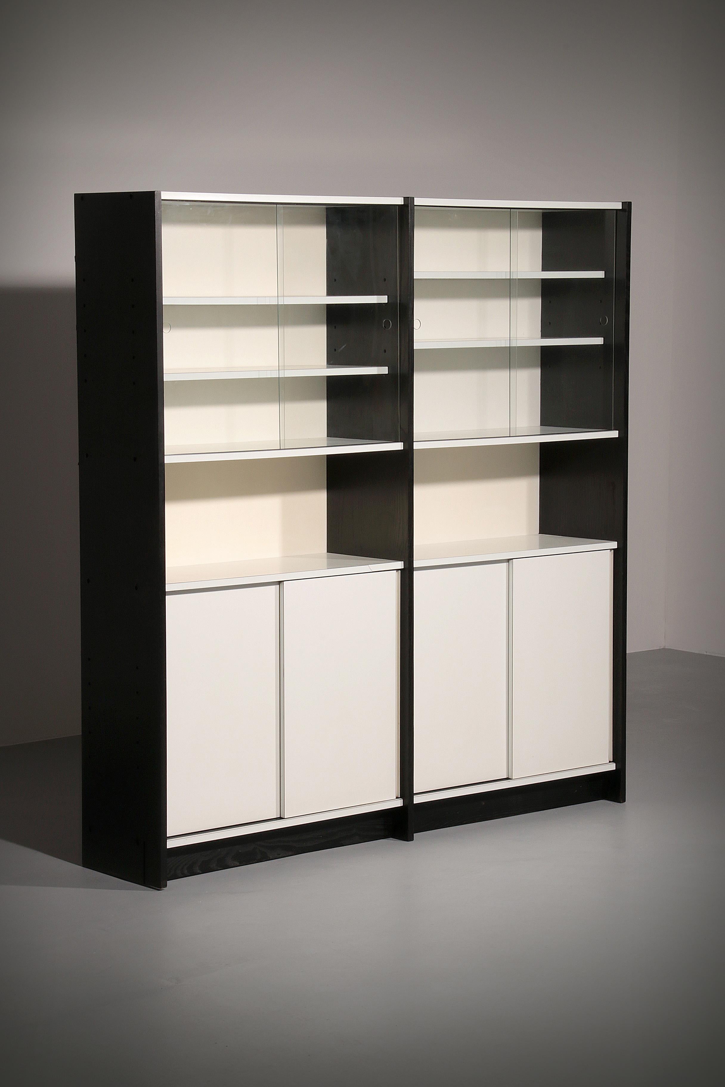 

Very nice modernist bookcase unit model WW72 designed by Martin Visser and manufactured by ‘t Spectrum, Holland 1965. This unit has black ebonized wooden side panels and white laminated shelves and sliding doors. Very nice bookcase with lots of