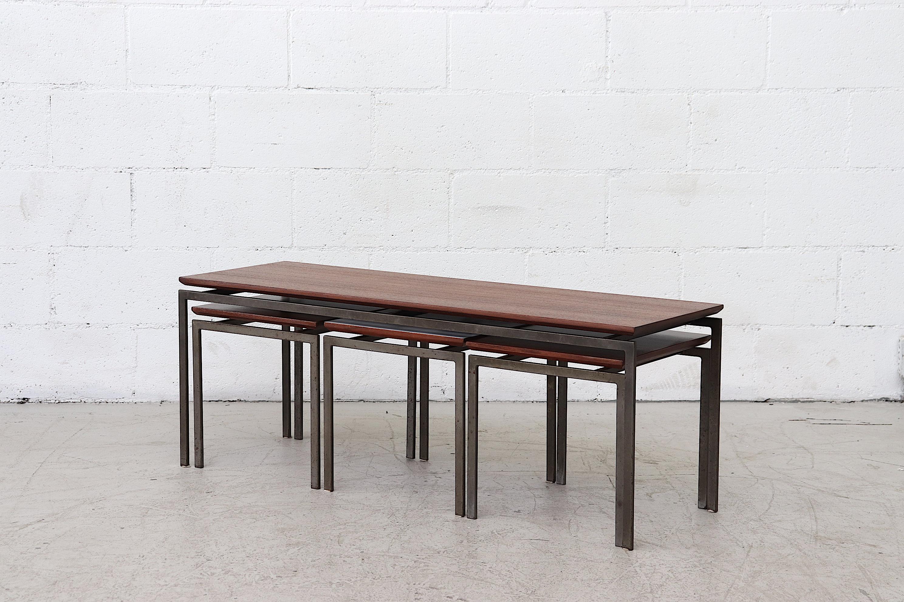 Set of 4 teak and Formica topped nesting tables with squared steel legs. Consists of one large long teak coffee or accent table with 3 small square nesting tables, 2 teak topped and 1 Formica topped table for contrast. In original condition with