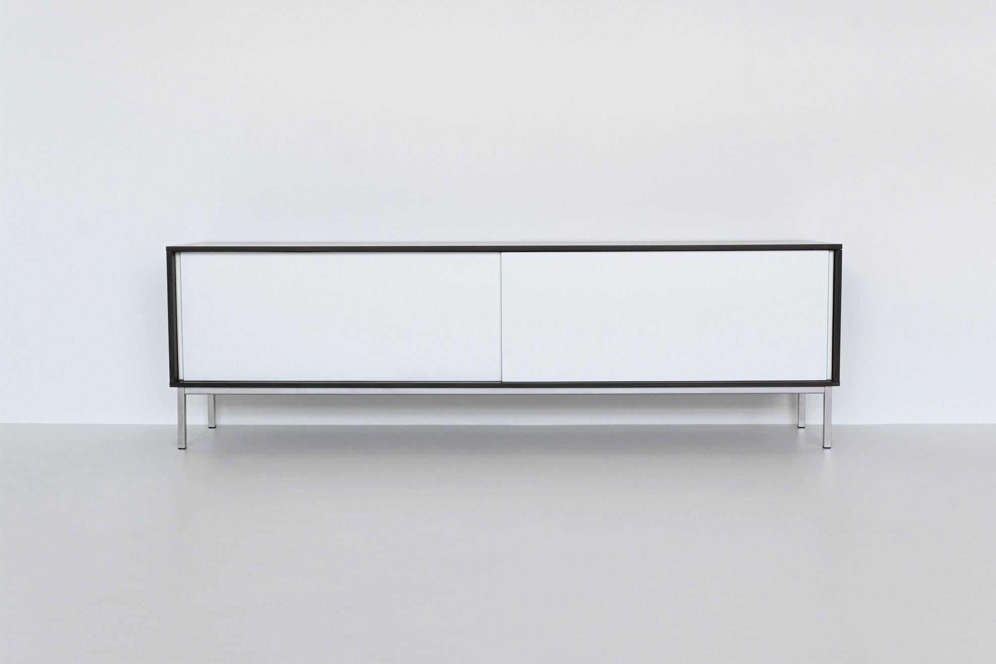 Beautiful minimalistic and modernist sideboard model KW85 designed by Martin Visser and manufactured by ‘t Spectrum Bergeijk, The Netherlands 1965. This longest version has a wenge wooden cabinet with two white laminated sliding doors supported by