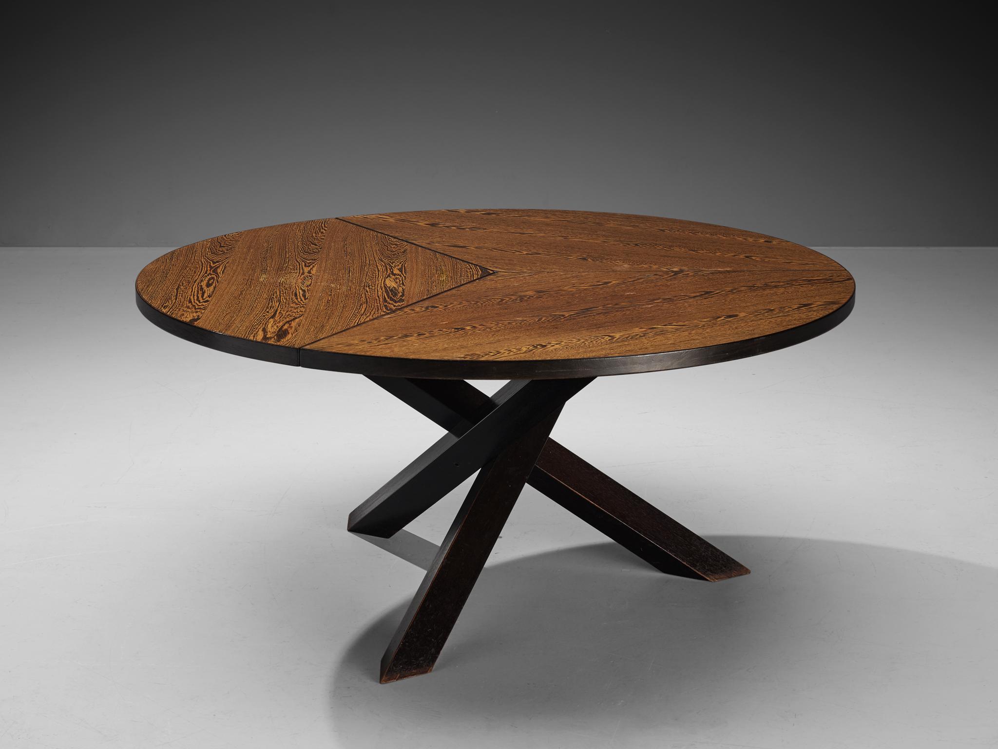 Martin Visser for 't Spectrum, dining table, wengé, stained wood, The Netherlands, 1960s.

Beautiful wengé dining table with round top, divided into three parts. The base consist of three crossed legs of solid, darkened wood. The veneer top shows an