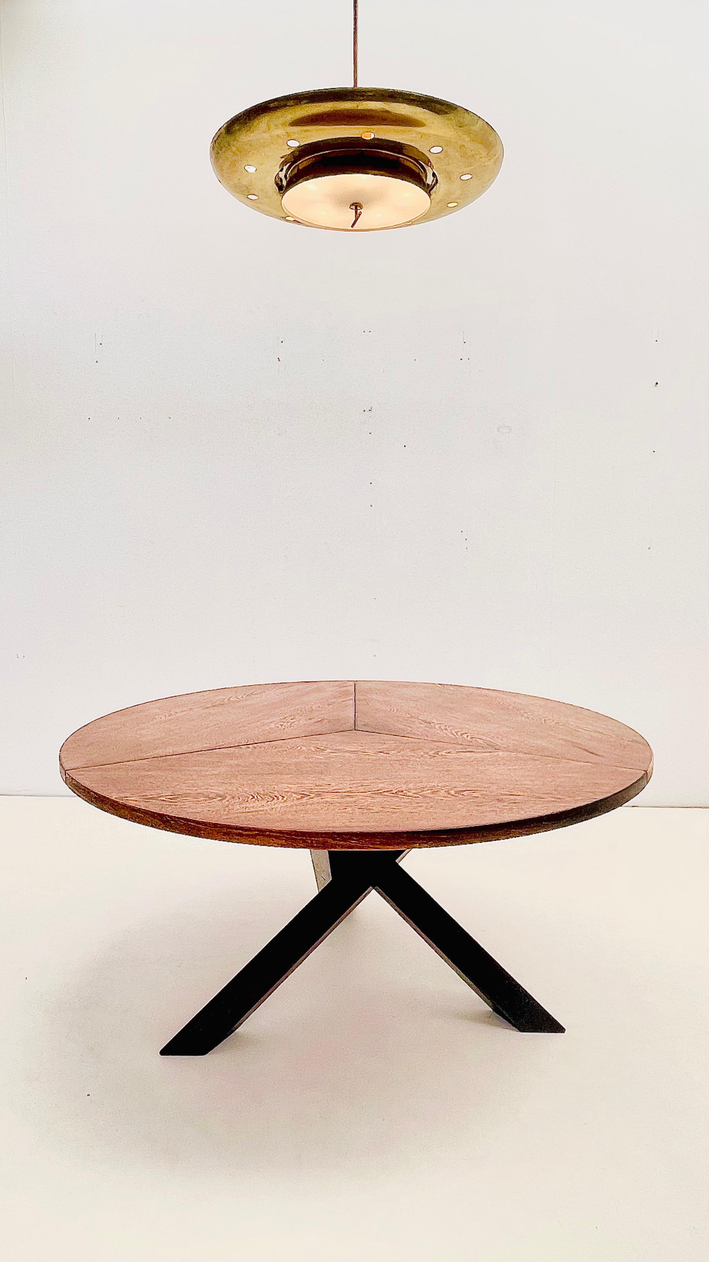 Stunning round dining table in wengé, designed by Martin Visser in the 1960s. The tabletop is divided into three distinct segments, showcasing the rich, expressive grain typical of this exotic hardwood. 

The striking base, formed by three