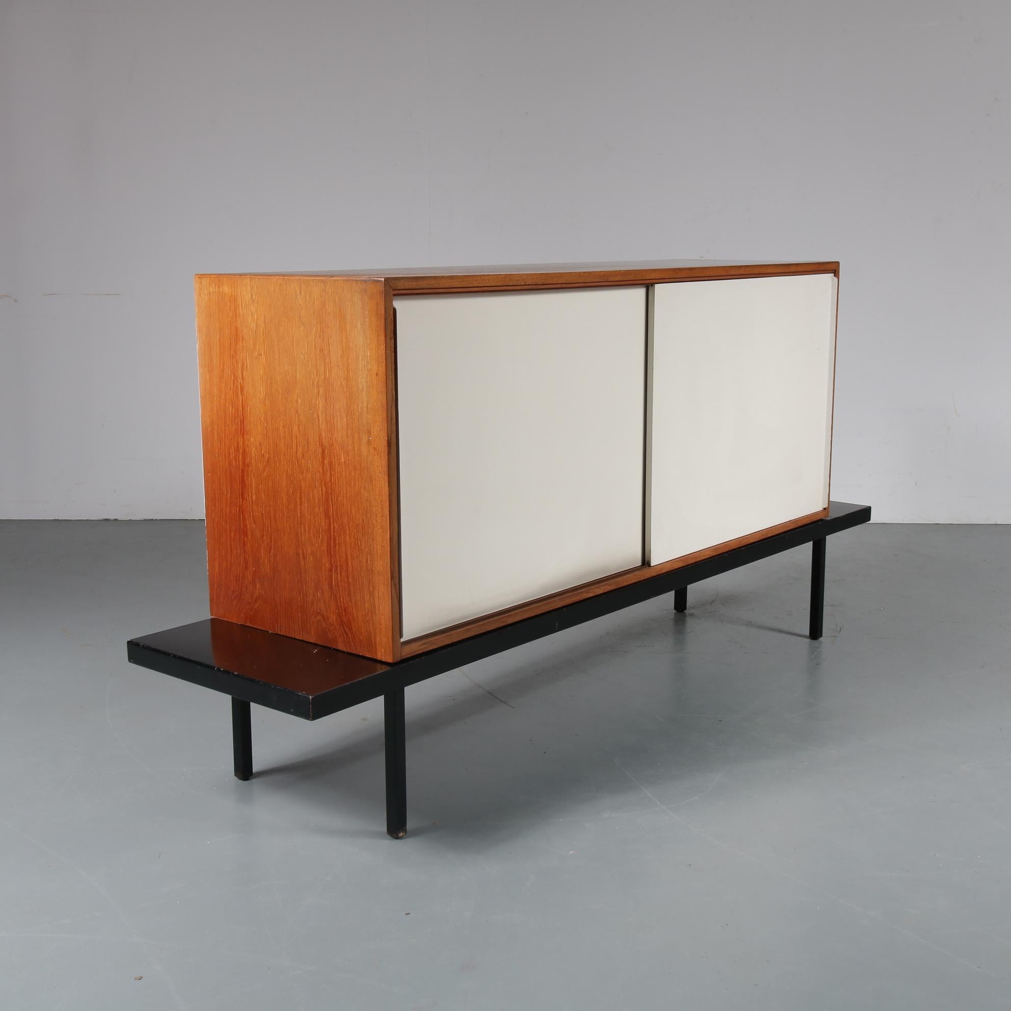 A beautiful sideboard designed by Dutch designer Martin Visser, manufactured by Spectrum the Netherlands around 1950.

This eye-catching piece has a black metal base holding the wooden cabinet, being a unique structure that allows movement of the