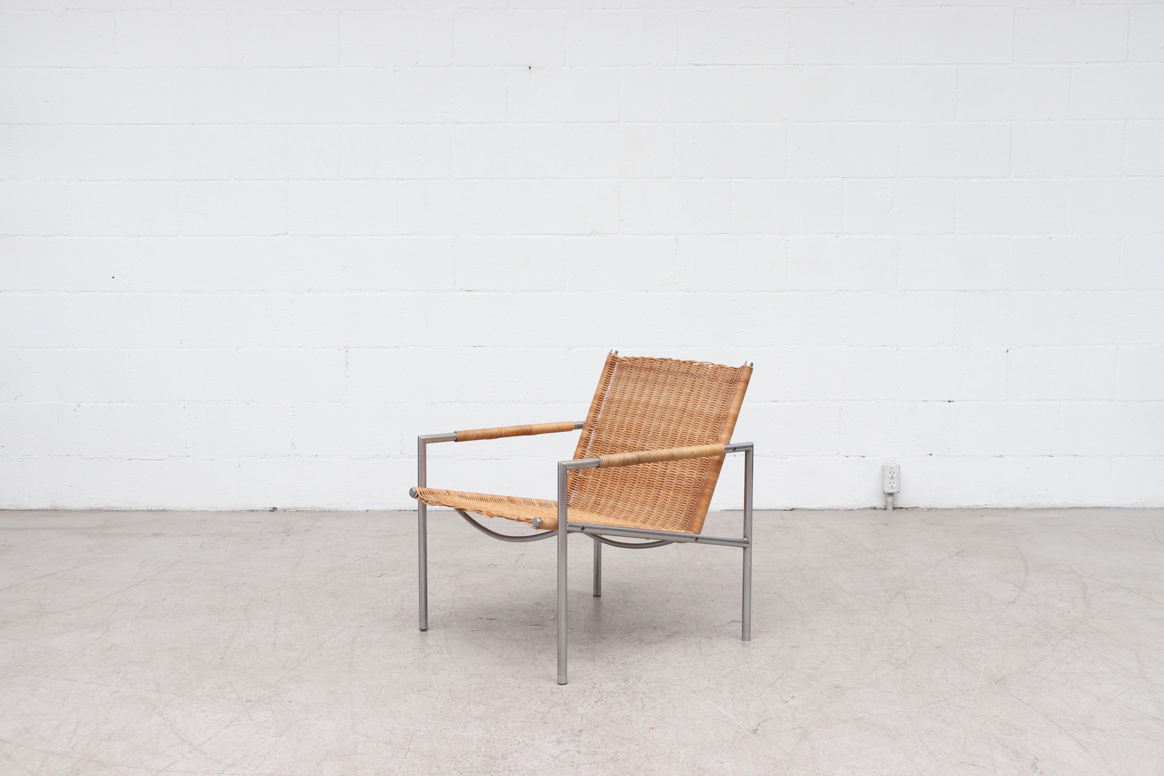 One of Martin Visser's well-known chrome and rattan lounge chair designs of the 1960s with Tubular chrome metal frame and rattan wrap detailing on arm rests. Martin Visser began working for Spectrum in 1954 as designer and head of collection. He had