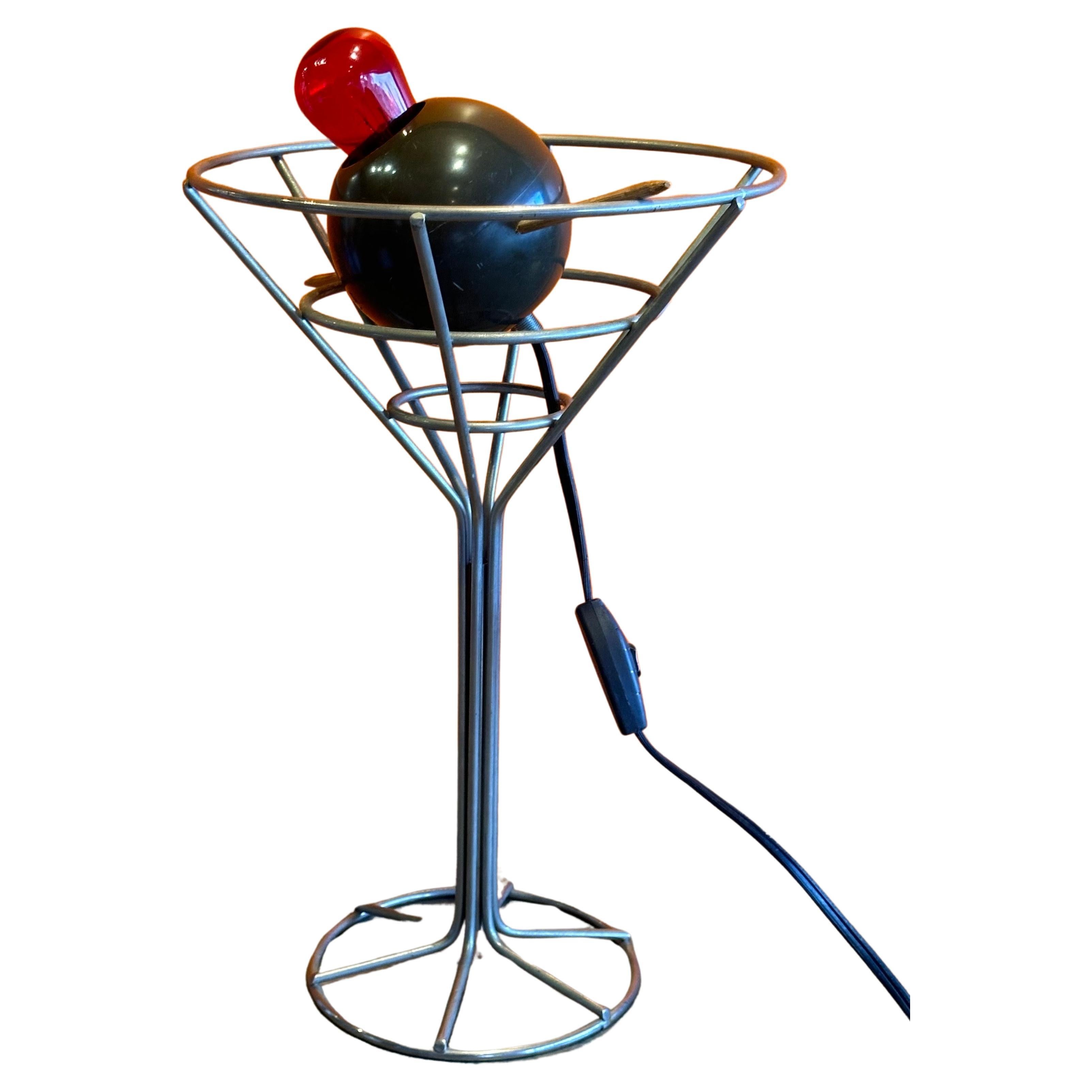 A unique and hard to find vintage martini with olive bar lamp by David Krys, circa 1990s. The pop art lamp is made of chrome and molded plastic and has a pimento red bulb with toothpick; this piece is extremely cool! The lamp is in good working