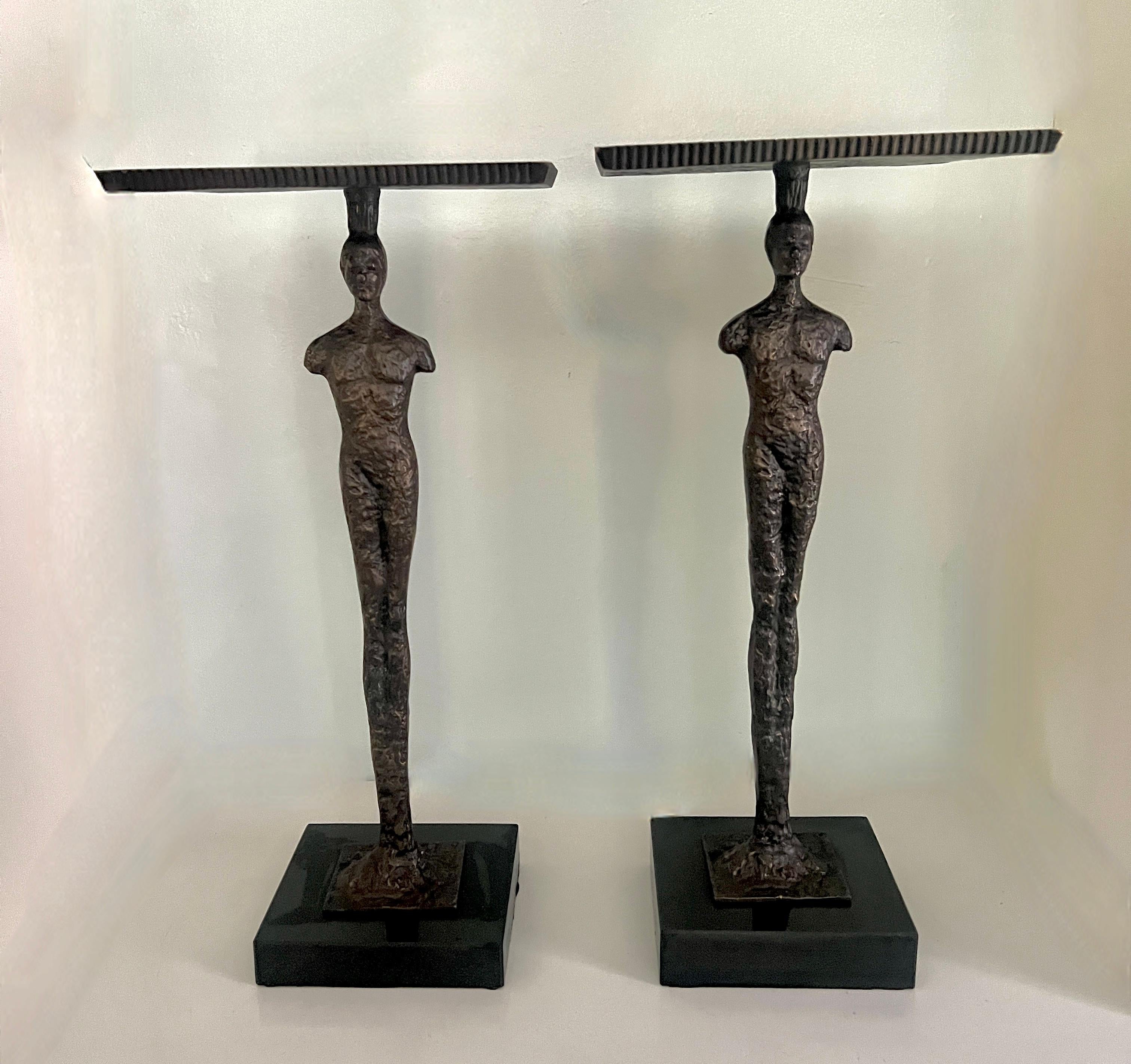 A pair of small Martini or Cigar Tables in the Style of Giacometti.  The pair are in the brutalist style with figures that have the look of a hand-crafted bronze.

The tops are also textured and sophisticated.  Both are on a metal base.

A