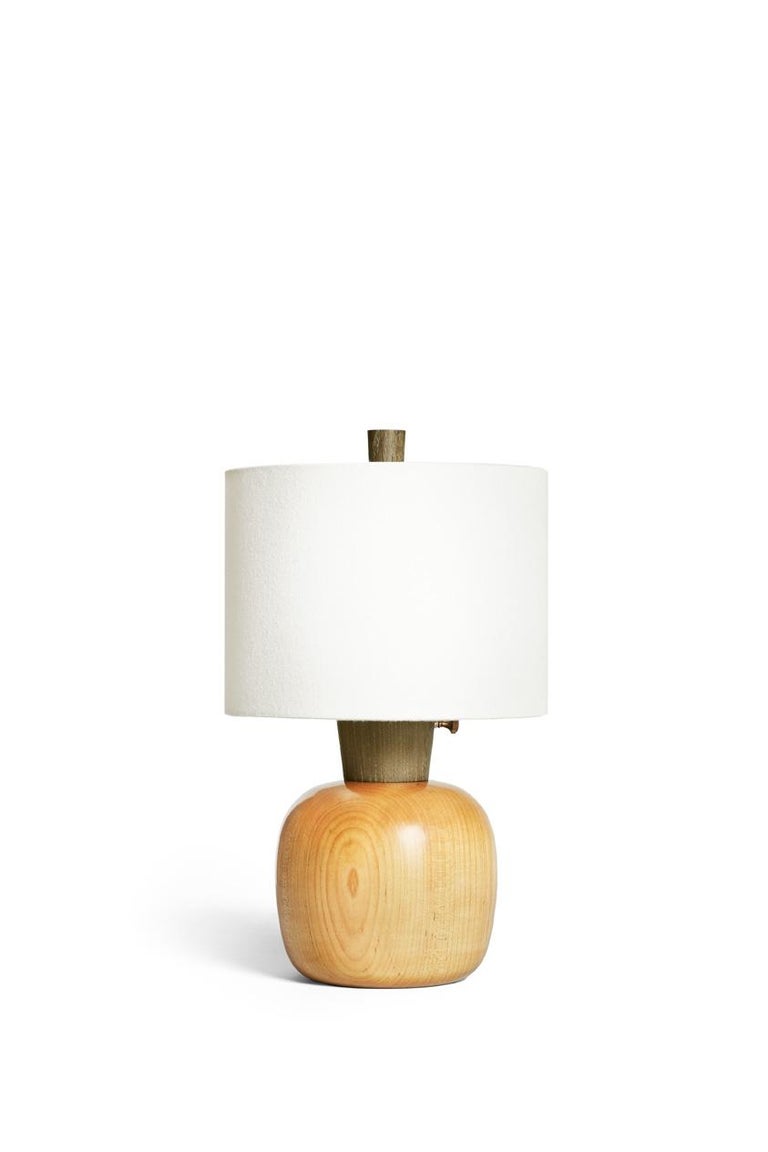 Small with a big presence, the Marty inhabits intimate spaces, scaled for the bedside or tabletop. Turned, ebonized maple base with an olive green-dyed ash neck and finial. This lamp is 14” tall with an 8” diameter trimless, natural linen shade.