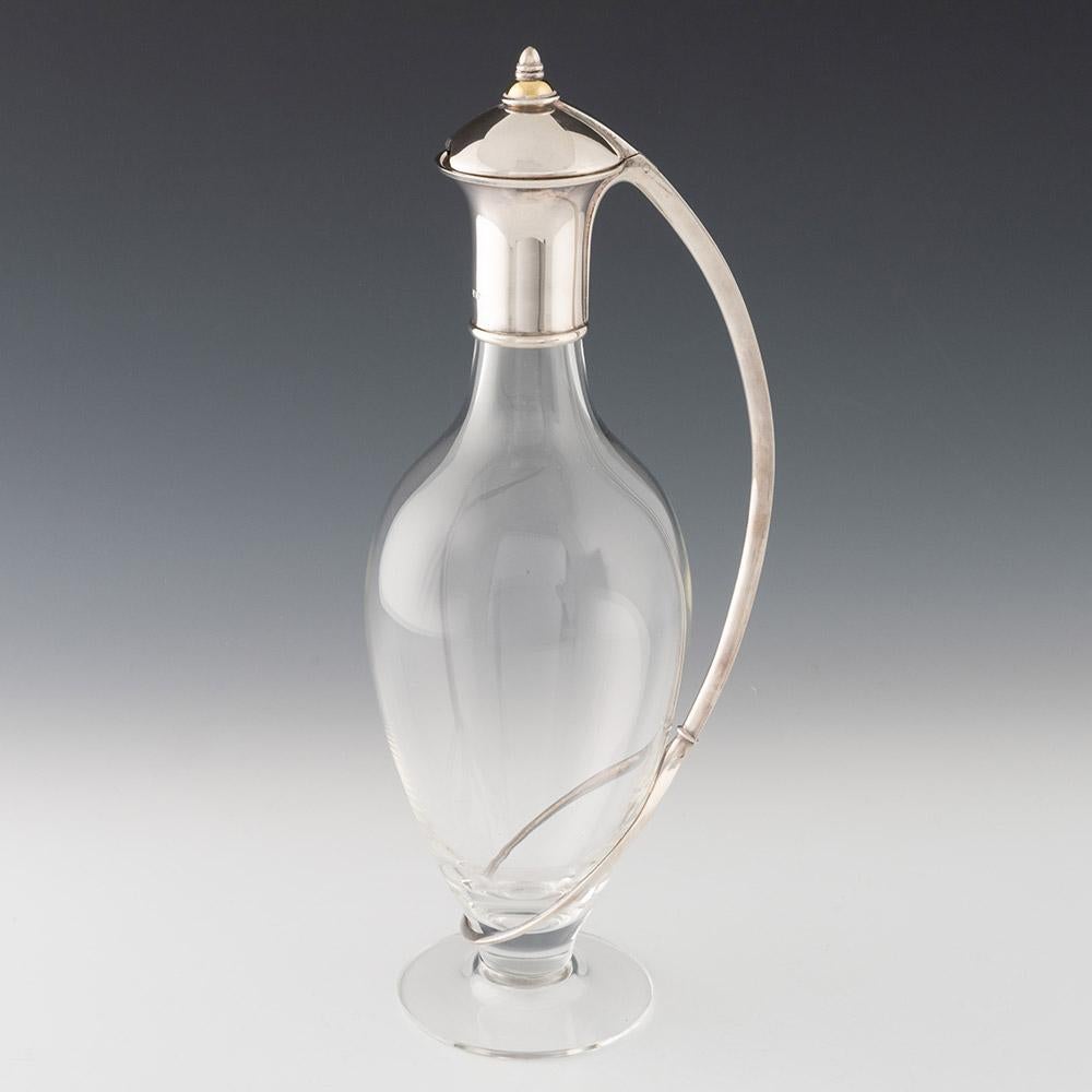 Heading : Silver and glass claret jug – ‘Curve’
Date : Hallmarked in Birmingham in 1997 for Martyn Pugh
Period : Elizabeth II
Origin : Birmingham, England
Colour : Clear glass and silver
Body : Silver cover with part gilded finial andcurve handle