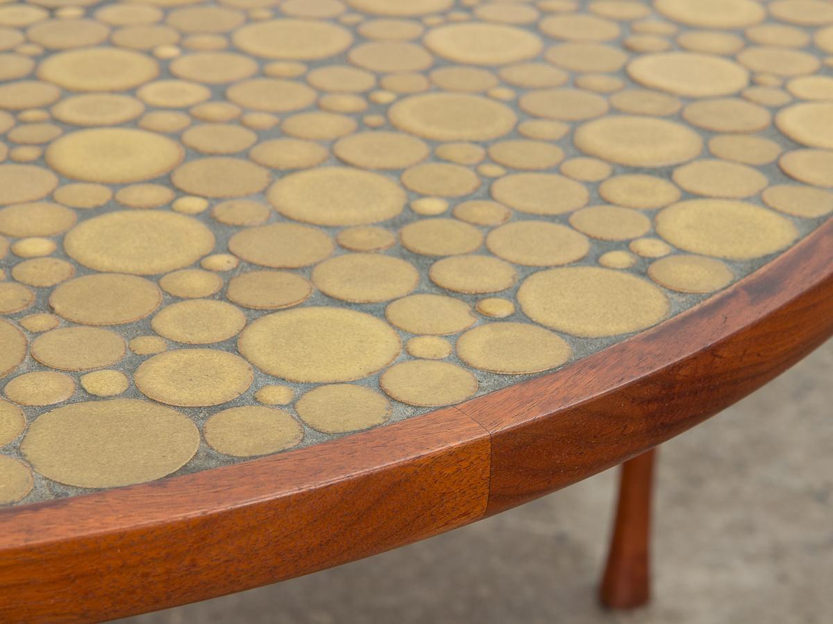 Lovely coin tile top coffee table, designed by Jane and Gordon Martz for Marshall Studio. Signature inlaid ceramic mosaic with deep ochre, yellow ceramic coin tiles. walnut wood form. Gleaming walnut base with playfully flared legs showcases high