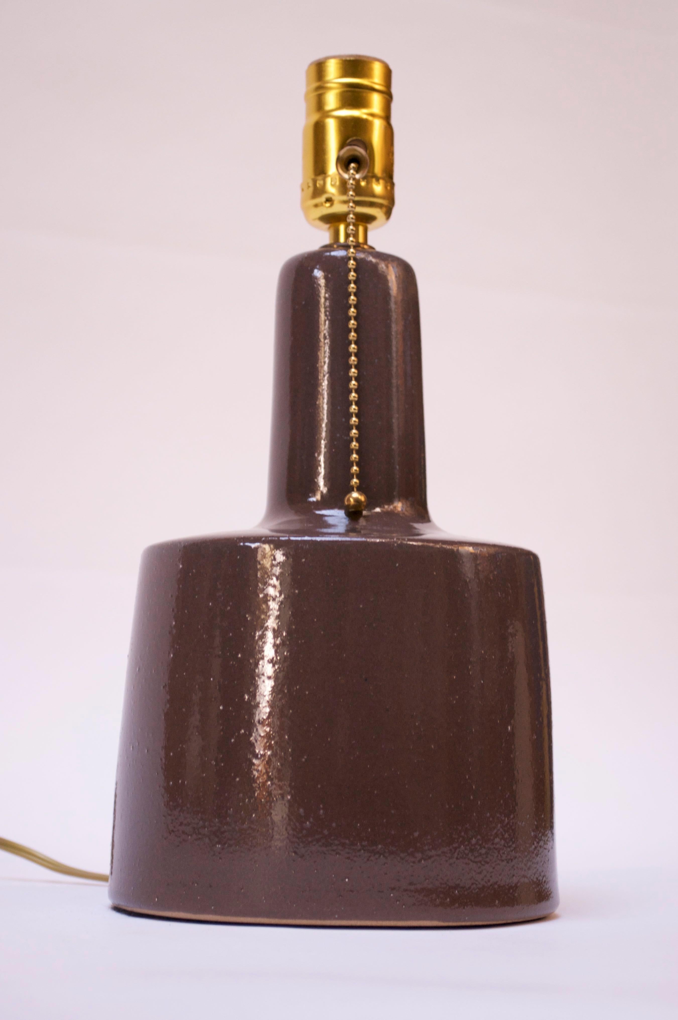 This petite, ceramic table lamp was designed by Gordon and Jane Martz for Marshall Studios in the 1960s. It is a high-gloss chocolate finish (which actually appears charcoal depending on the light / angle) with a highly textured, mottled surface.