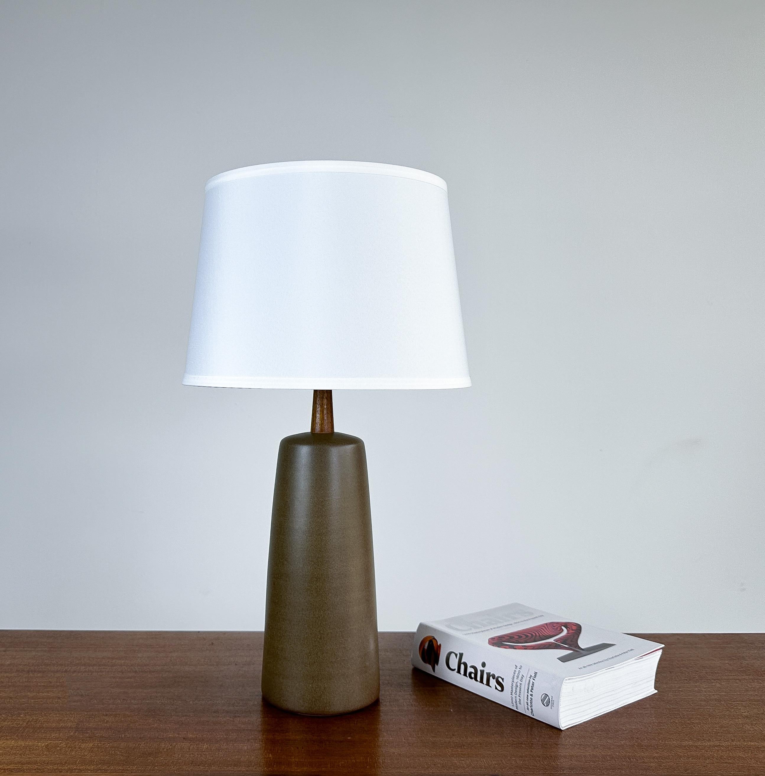Offered is a fantastic table lamp by renowned duo Jane and Gordon Martz for Marshall Studios, circa 1960s.

Featuring a lovely, lightly speckled cocoa glaze paired with the signature solid walnut neck and finial. This particular model has wonderful