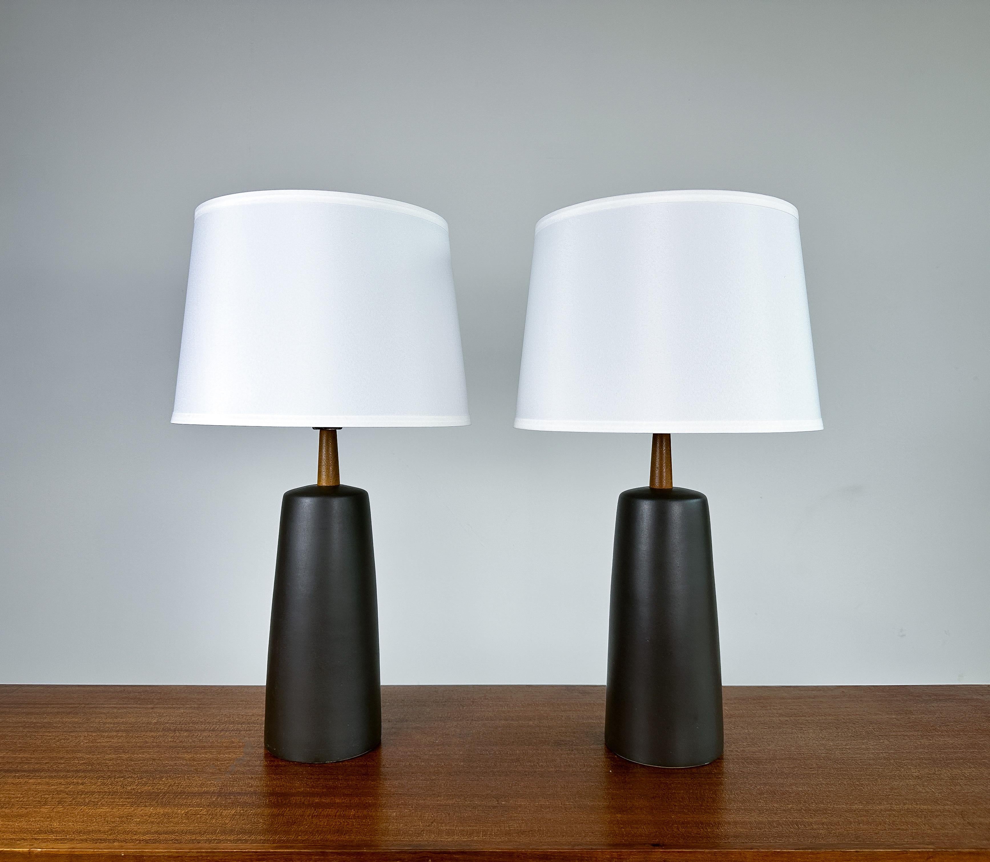 Offered is a fantastic pair of table lamps by renowned duo Jane and Gordon Martz for Marshall Studios, circa 1960s.

Featuring a lovely charcoal glaze paired with the signature solid walnut neck and finial. These lamps have such a wonderful presence