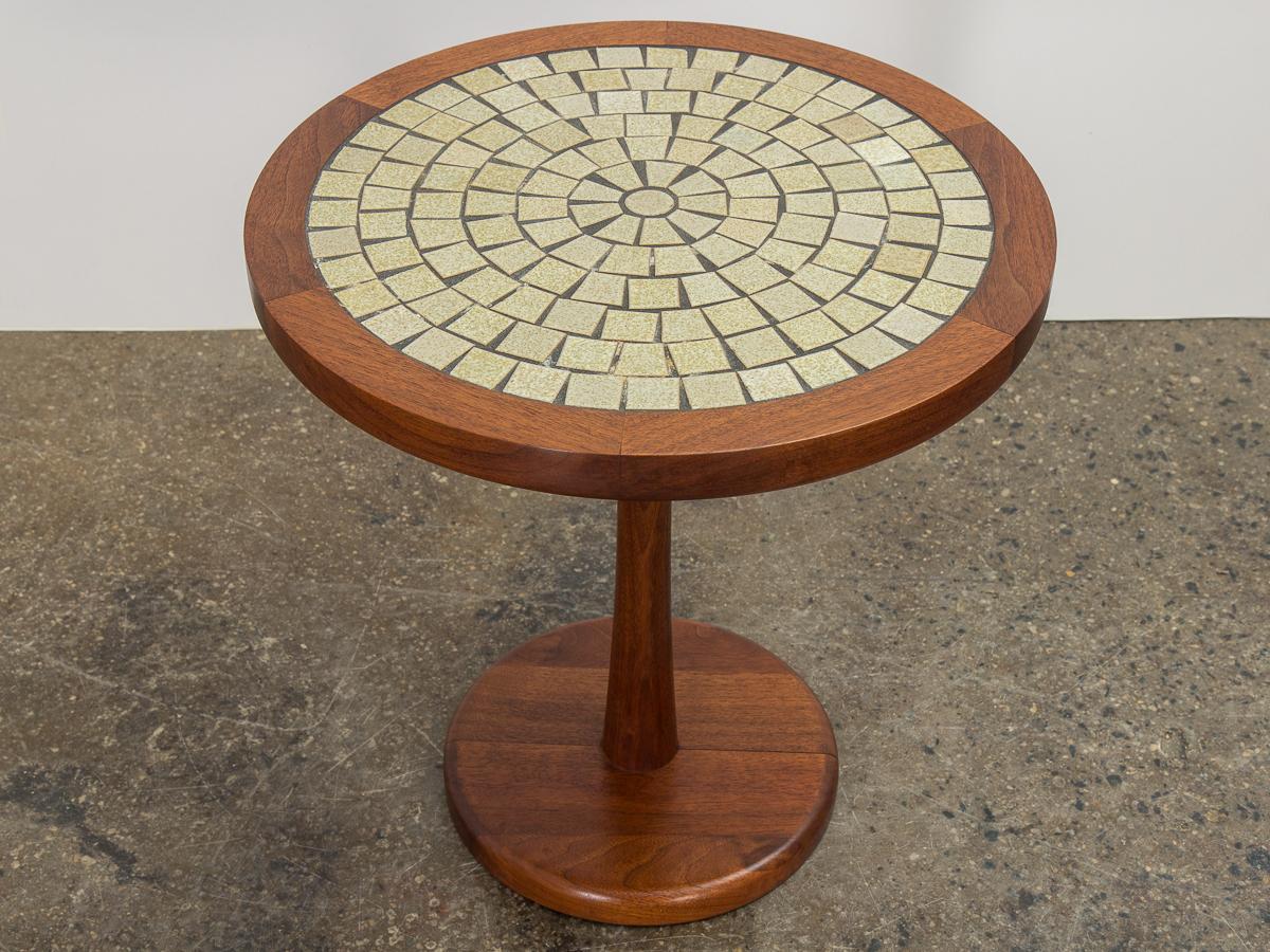 Mosaic tile top pedestal side table, designed by Jane and Gordon Martz for Marshall Studios. Signature inlaid ceramic mosaic in earthy tones with subtle green hues. Well-supported by heavy, solid wood base. Walnut frame is in wonderful condition,
