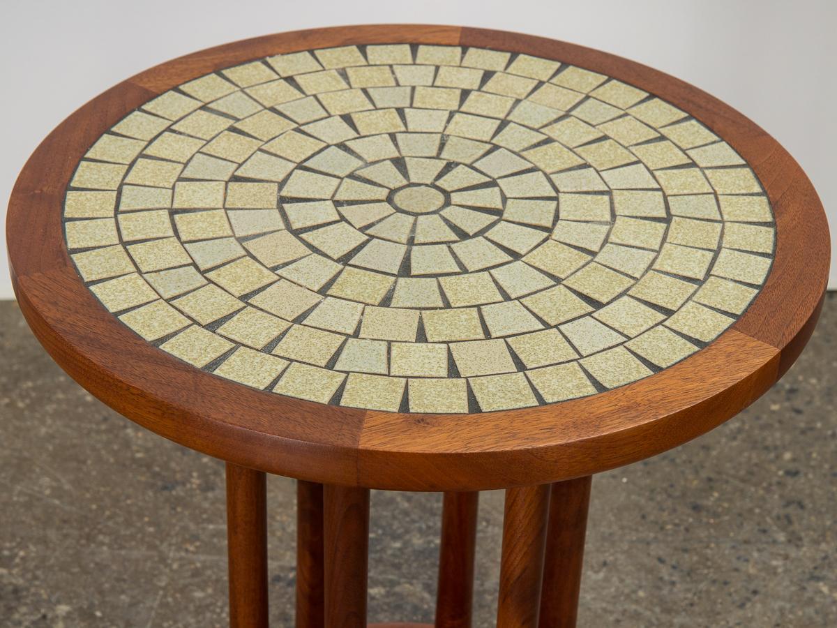 Pair of mosaic tile top side tables, designed by Jane and Gordon Martz for Marshall Studios. Signature inlaid ceramic mosaic with earthy tones with subtle green hues. An unusual silhouette, six dowel walnut base shows exceptional craftsmanship.
