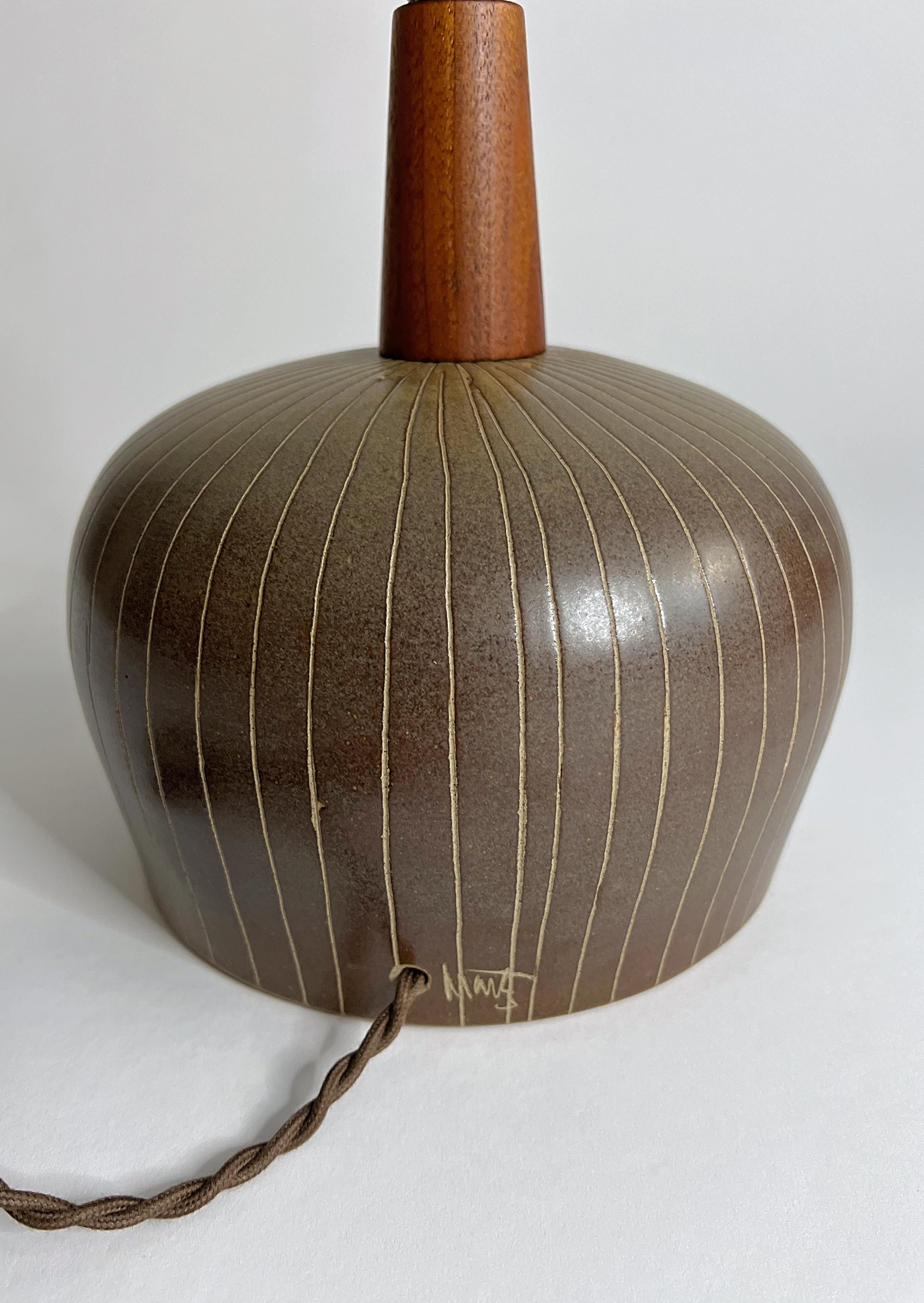 Petite lampe de table marron et verte unique en son genre, réalisée par Jane et Gordon Martz pour Marshall Studios, dans les années 1960. Cette lampe est très rare et se montre bien. 

Les teintes sont brunes avec un vert profond et un motif incisé