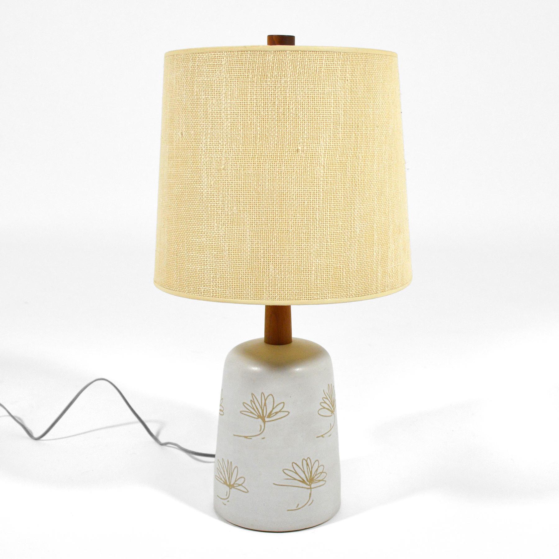This terrific lamp by Gordon and Jane Marts for Marshall Studios features a delicate floral design rendered in sgraffito on the eggshell white glazed base. It retains its original shade and walnut finial.