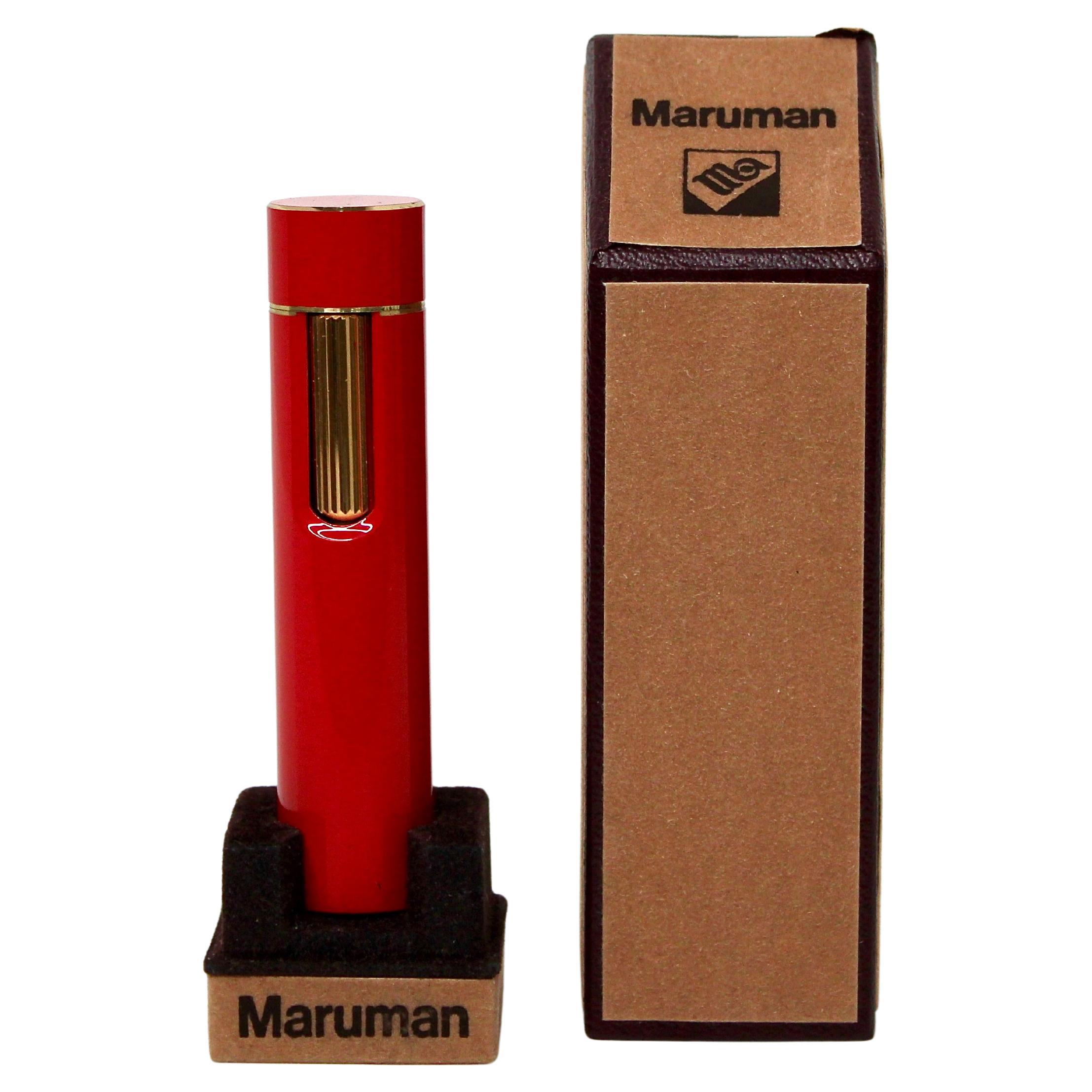 Le briquet à cylindre en laque rouge de Maruman, datant des années 1970, est un exemple frappant de luxe et de savoir-faire vintage. Sa finition laquée rouge vibrante, complétée par d'élégants détails dorés, dégage un sentiment de sophistication et