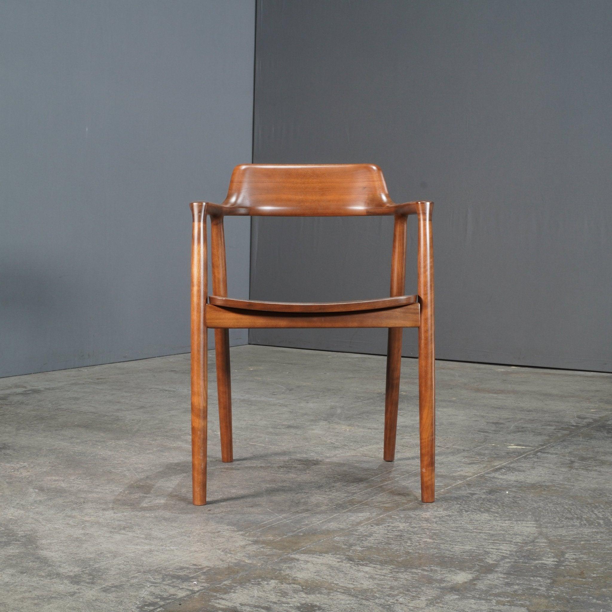 The Maruni Hiroshima Wooden Armchair exudes refined craftsmanship and minimalist design, epitomizing the elegance of Japanese furniture. Crafted from solid wood, this armchair features smooth, gently curved lines and an ergonomic form that offers