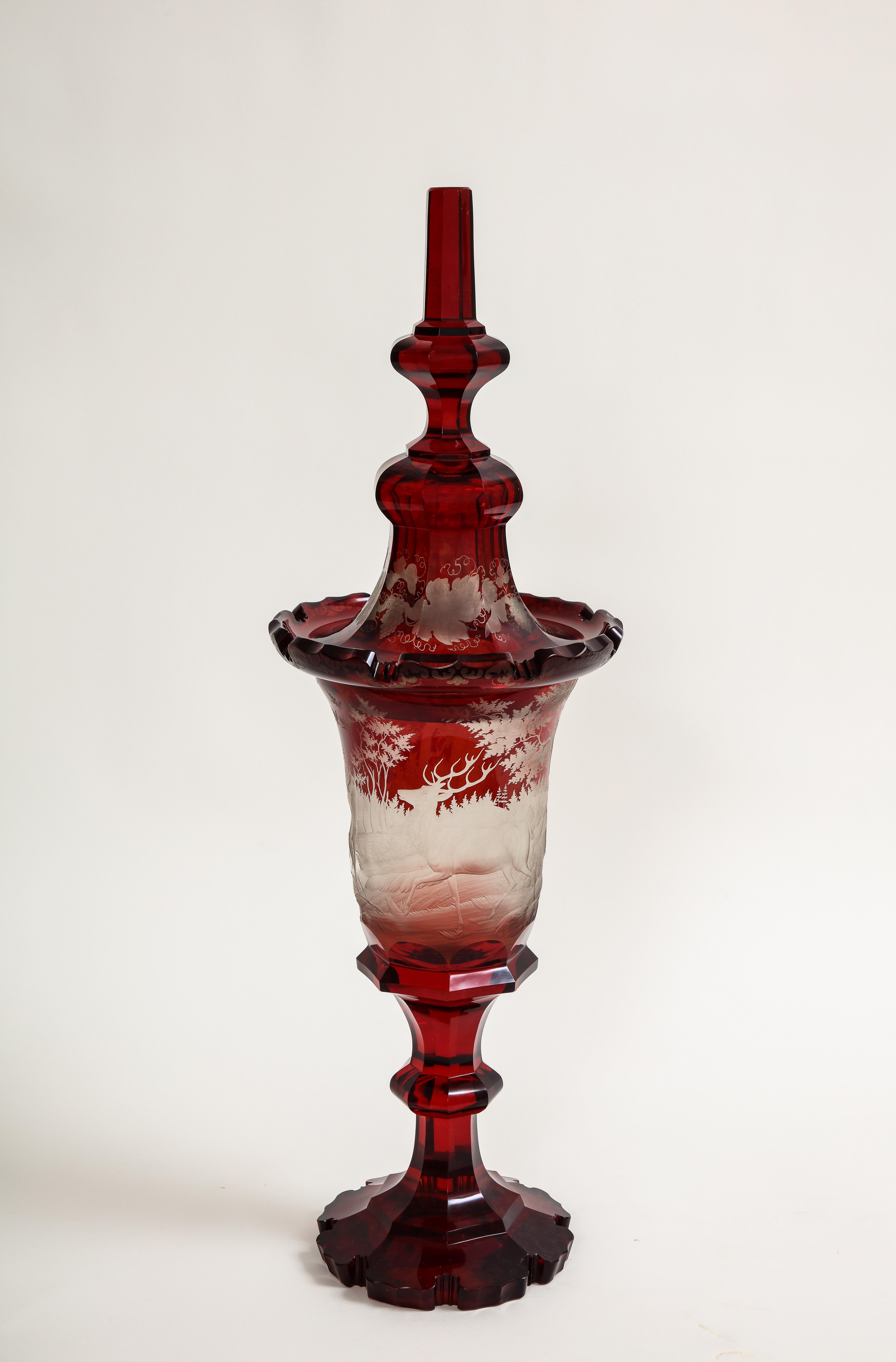 Marvelous Bohemian Rot-Schliff-zu-Klar-Kristall-Jagd-Szene abgedeckt Pokal.  Der Pokal besteht aus einem urnenförmigen Korpus mit Deckel und einem facettierten, abgestuften Sockel. Das Glas ist rot-geschliffenes, klares Kristall, wobei die rote