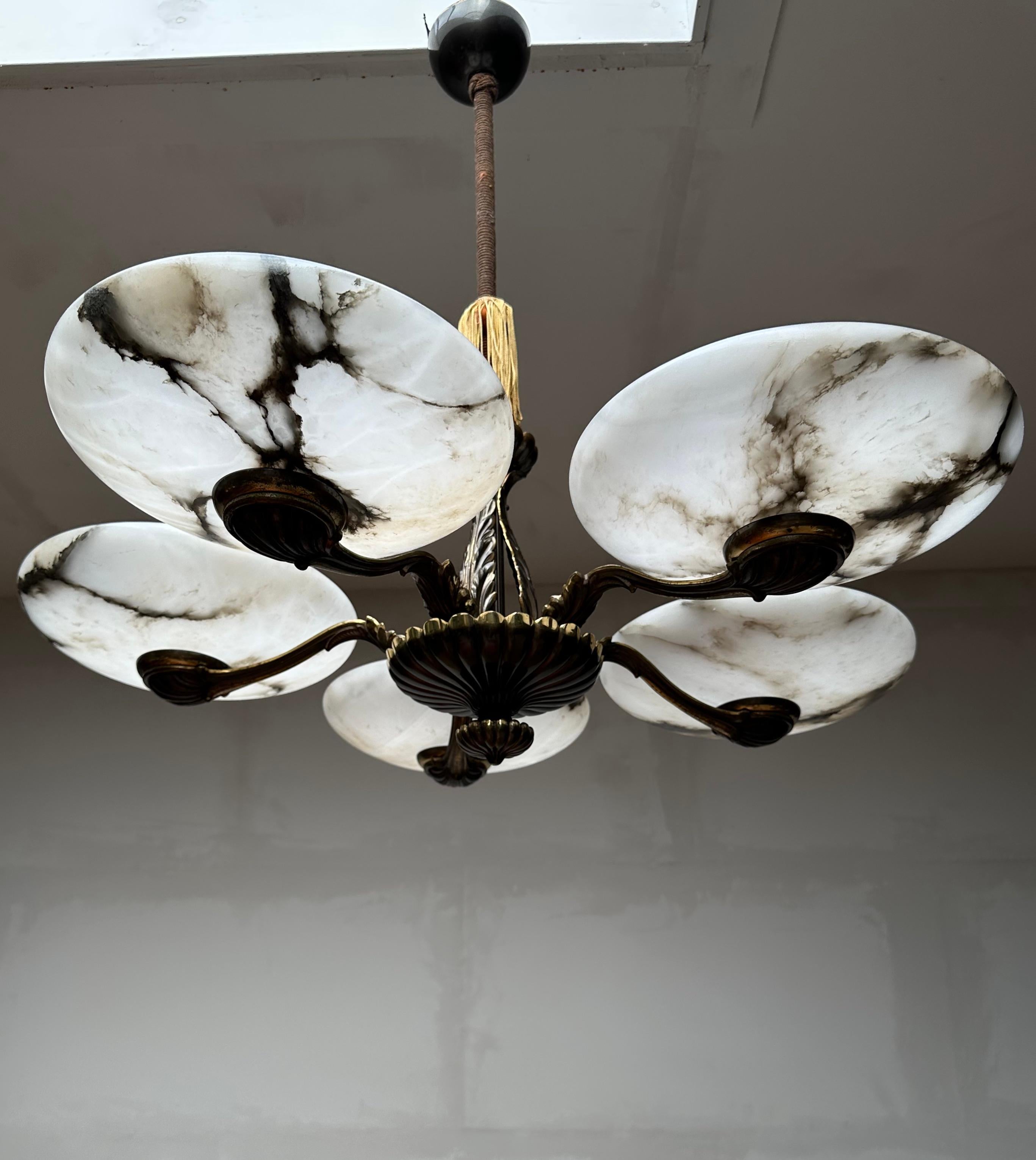 Striking and exclusive 1920s bronze and alabaster light fixture for the perfect atmosphere.

If you are looking for a remarkable light fixture to grace your living space then this antique Art Deco chandelier from the earliest years of the 20th