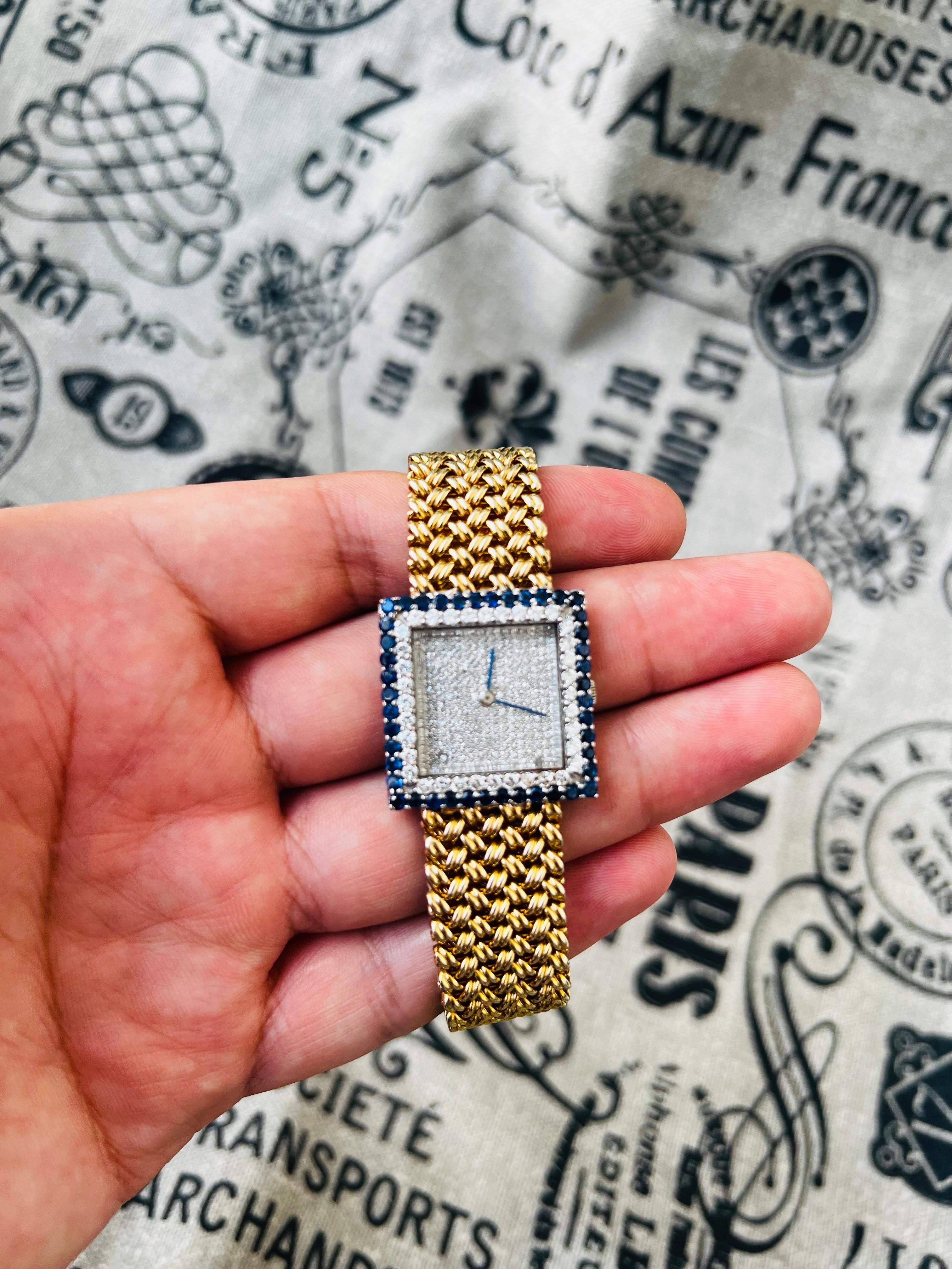 An 18K Bueche Girod wristwatch accented with diamonds and sapphires, with a yellow gold mesh-weave bracelet with fold over clasp. Watch movement is manual wind and the watch is currently running, Band: approx. 7-1/2in long × 3/4in wide at widest