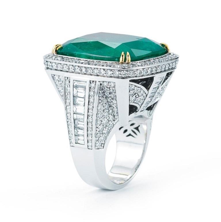 MARVELOUS EMERALD AND DIAMOND RING A beautiful cushion shaped emerald of extraordinary color is set between round and emerald cut diamonds Item: # 01707 Metal: 18k W Lab: Agl Color Weight: 52.85 ct. Diamond Weight: 7.05 ct.
