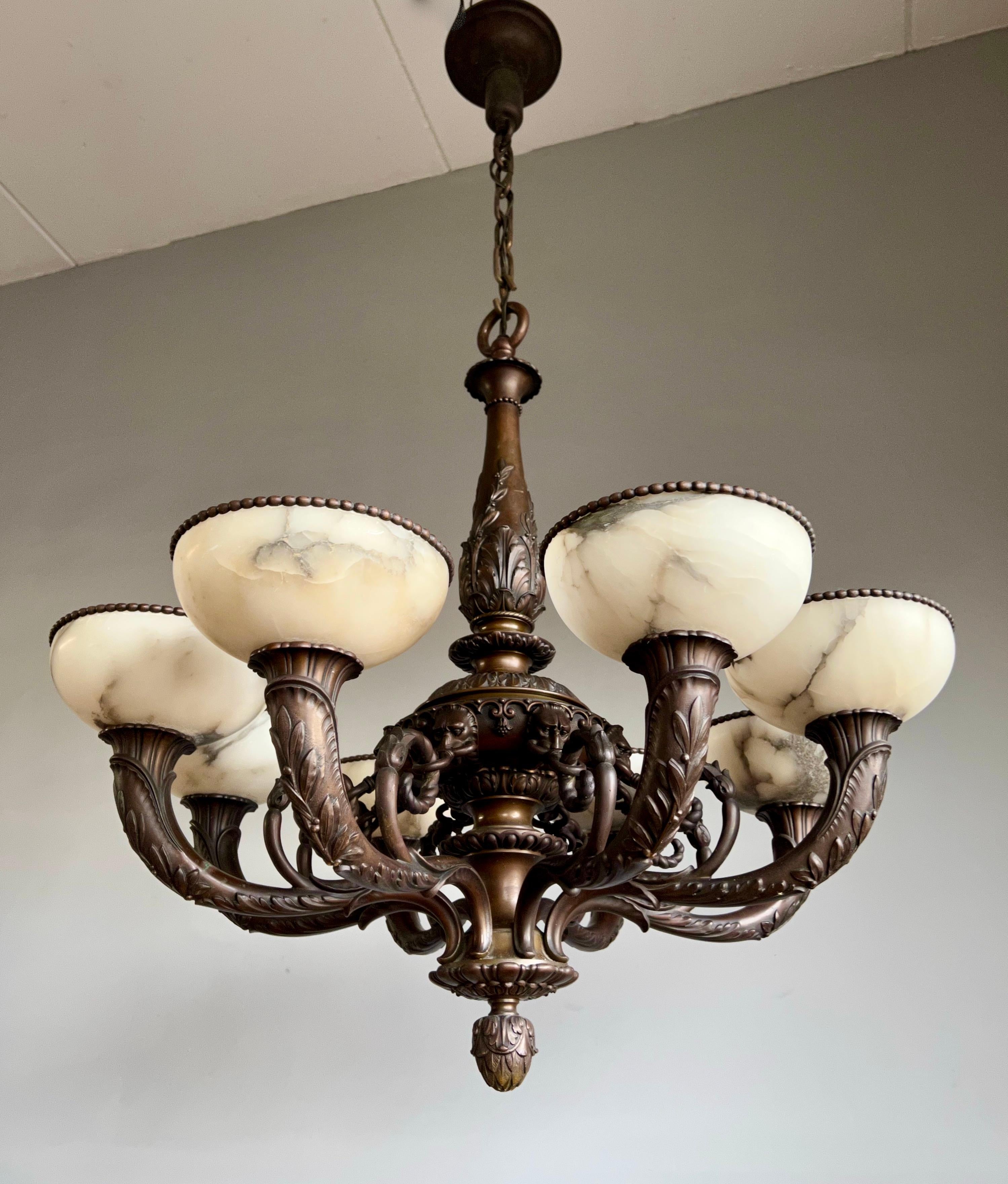 Striking and exclusive 1920s bronze and alabaster light fixture for the perfect atmosphere.

If you are looking for a remarkable light fixture to grace your living space then this antique and large bronze 8 arm chandelier with stylish lion