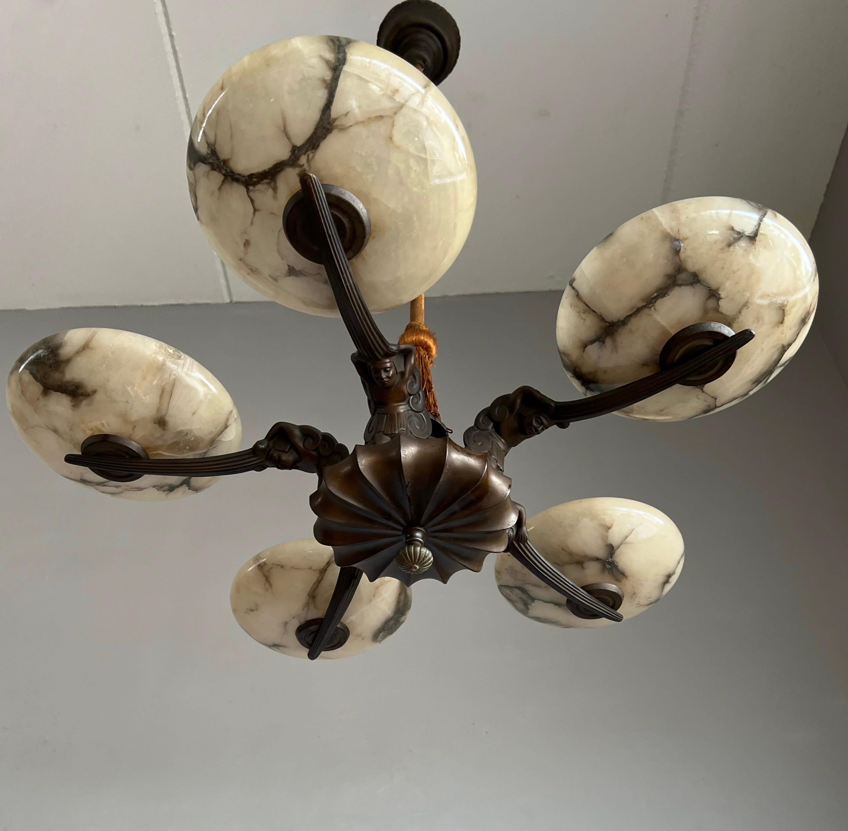 Striking and exclusive 1920s bronze and alabaster light fixture for the perfect atmosphere.

If you are looking for a remarkable light fixture to grace your living space then this antique Art Deco chandelier from the earliest years of the 20th