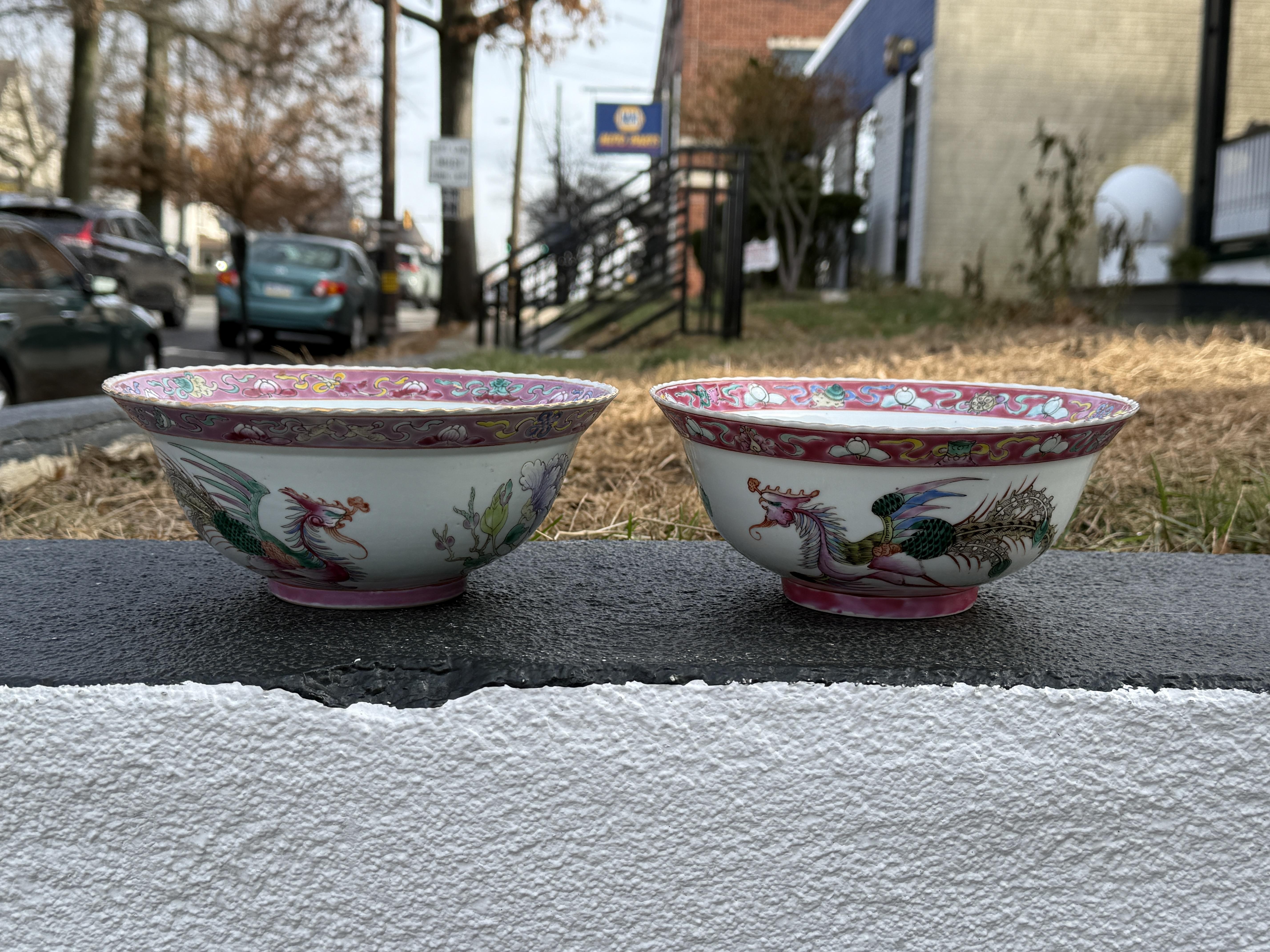 Se trata de un par de cuencos de porcelana Peranakan Nonya bellamente elaborados con un intrincado diseño de un colorido ave fénix. Los cuencos están adornados con un vibrante borde rosa, ornamentado con motivos florales y volutas. El ave fénix está