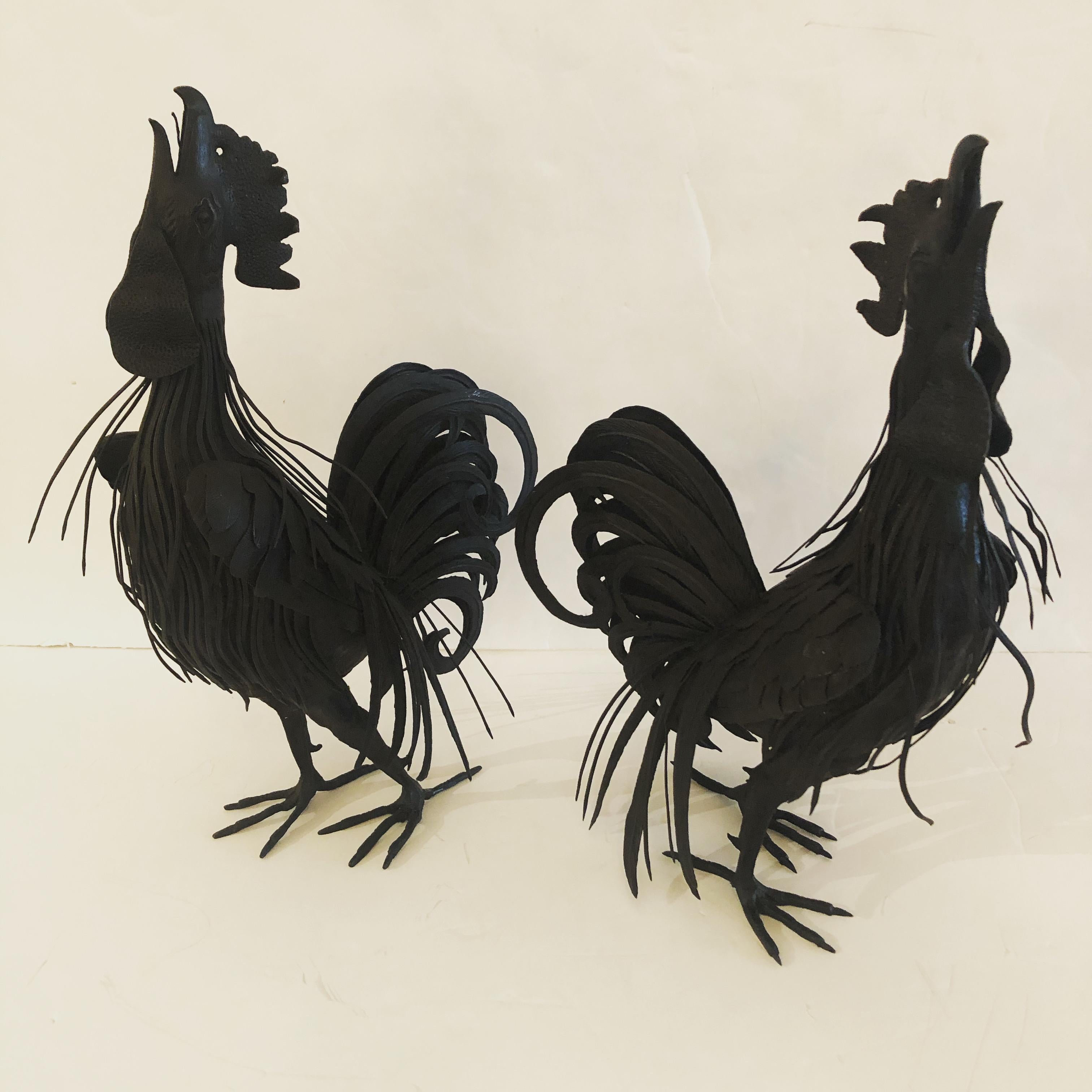 A fabulous pair of vintage hand forged black iron rooster sculptures having terrific details and crowing poses.