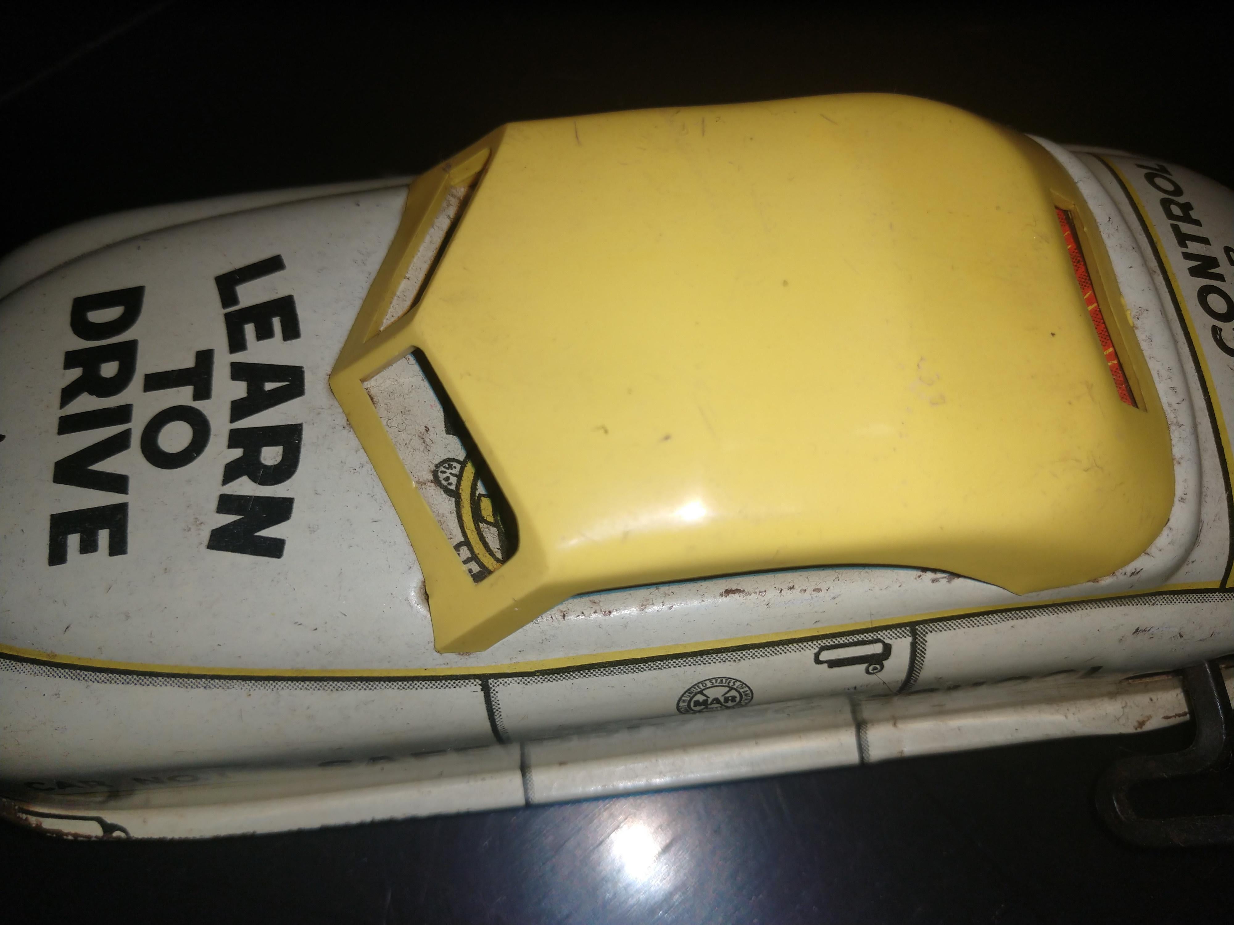 Windup tin Litho toy car with Dual action mechanism. When wound car has two windups that keep car moving and in some situations will prevent it from falling off of edges. Minor paint loss on front fender, graphics are still bright. Plastic roof.