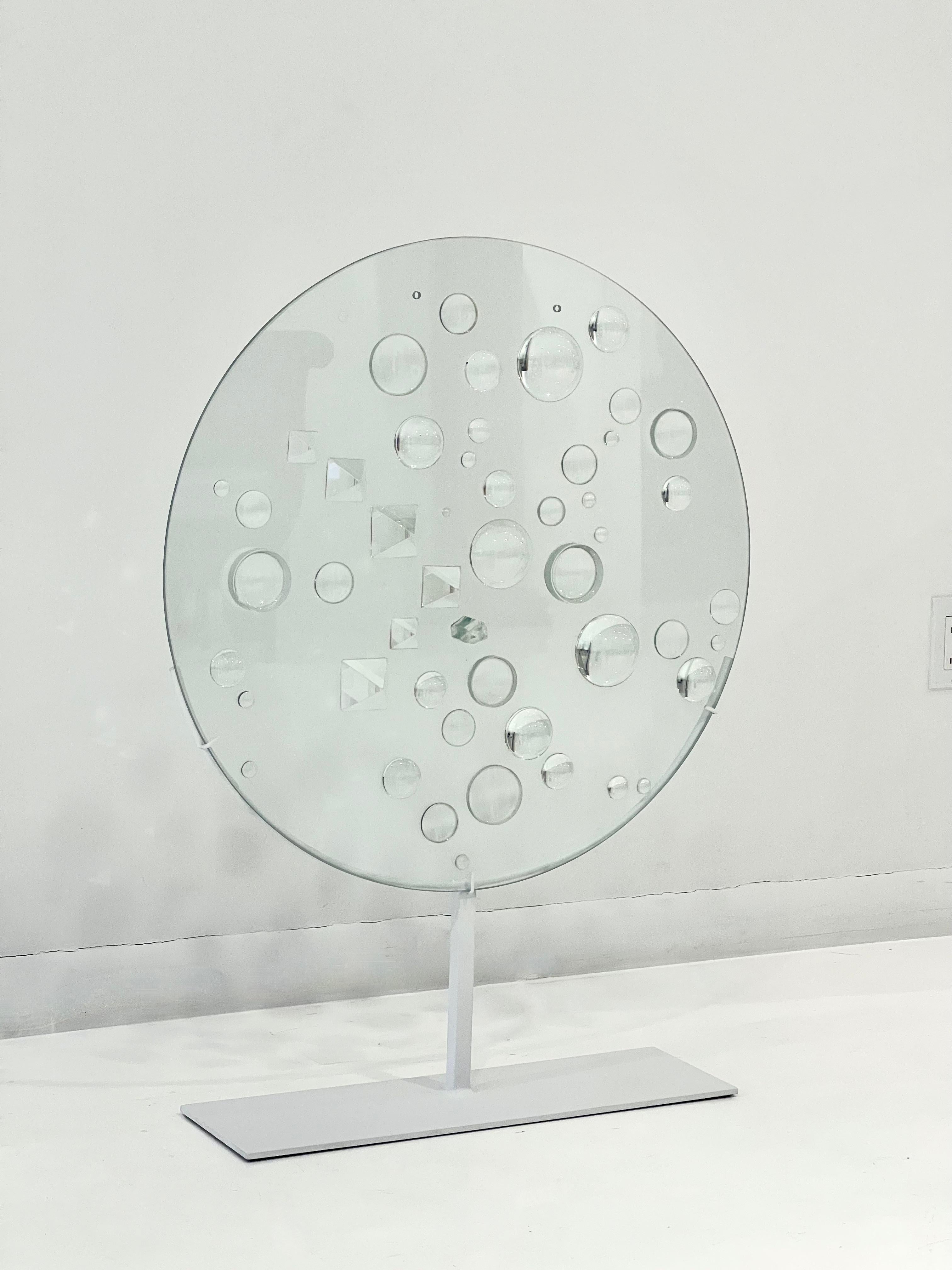 Optical Glass Disc Sculpture by May Hilde Ruth Bauermeister, USA, circa 1960's. Glass disc on metal stand with a variety of scaled lenses, both convex and concave, refracting and reflecting the collected light. Mary Bauermeister's work is