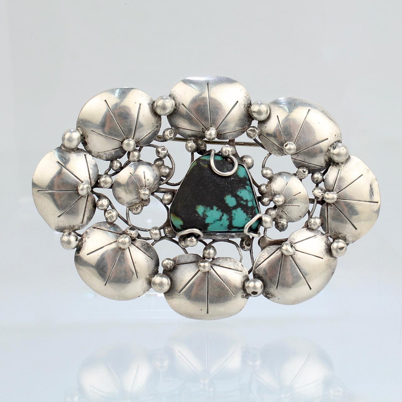 A wonderful Mary Gage lily pad brooch. 

In sterling silver with stylized lily pads surrounding a central turquoise gemstone. 

Marked to the reverse Sterling and Mary Gage.

Simply a wonderful brooch from a renowned female American jewelry