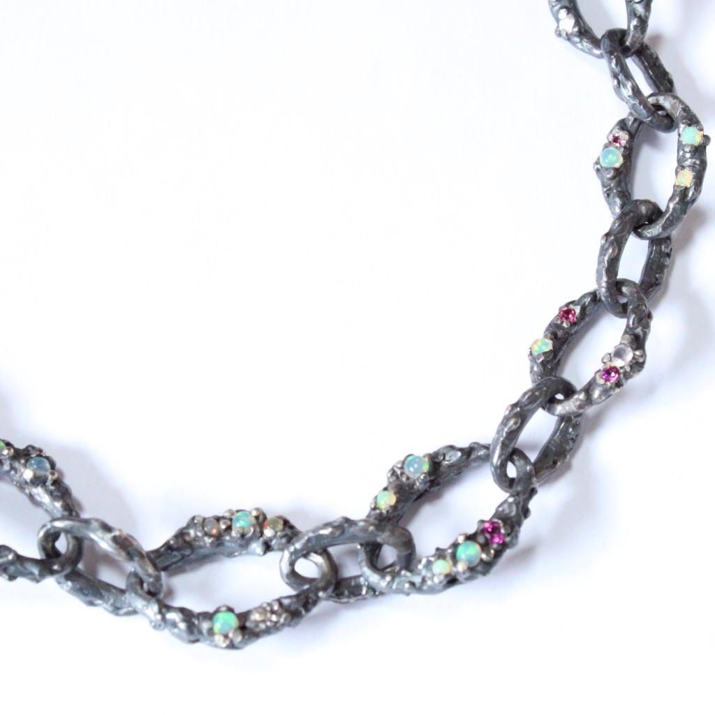 This fully fabricated hand cast and soldered sterling silver chain is set with a mix of rose quartz, rhodolite pink and purple garnets along with deep red garnets. Designed to emulate buried treasure- submerged for centuries under water- this choker