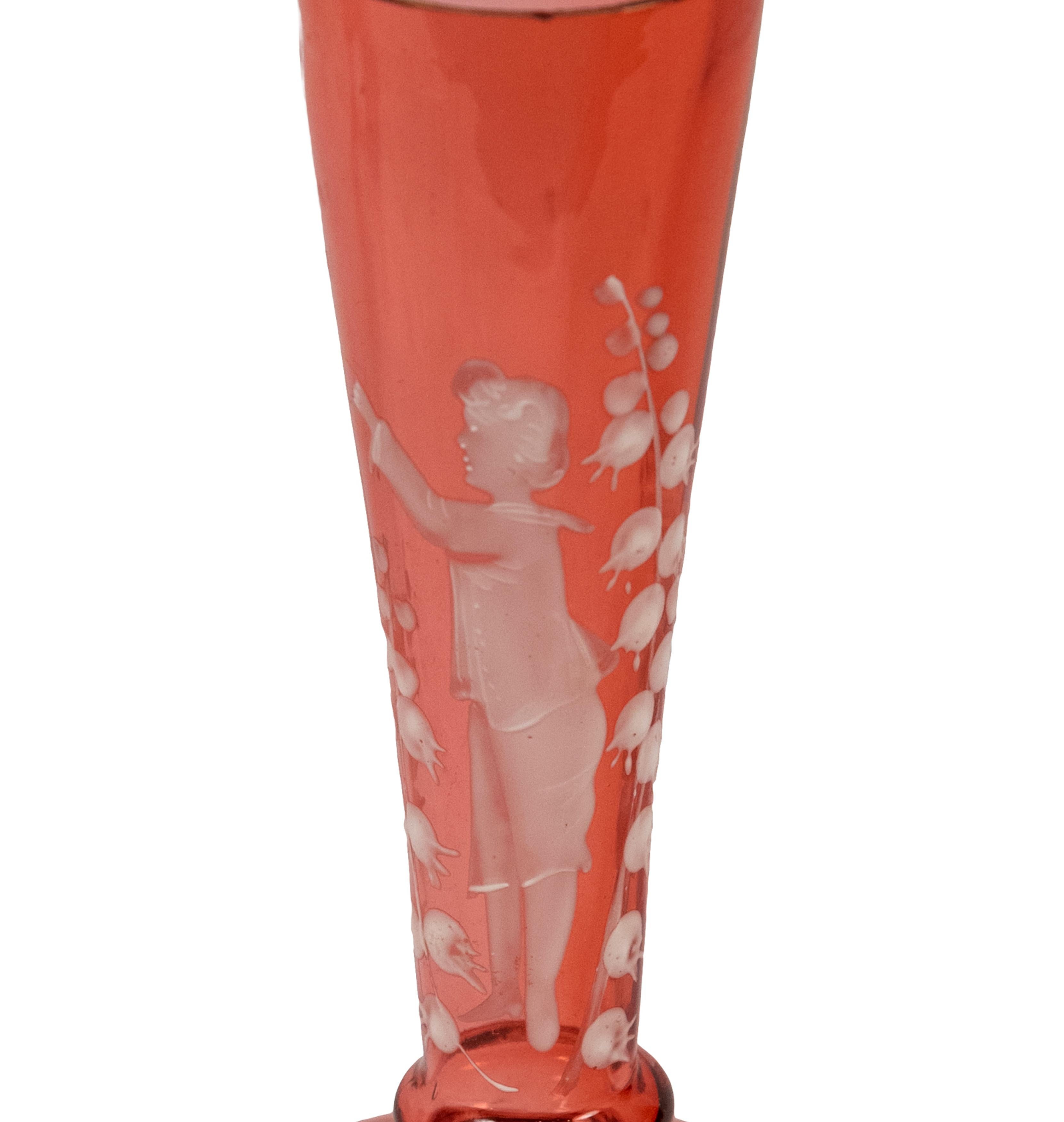 Mary Gregory cranberry-colored bud vase with white enamel decoration of a young boy surrounded by vines.