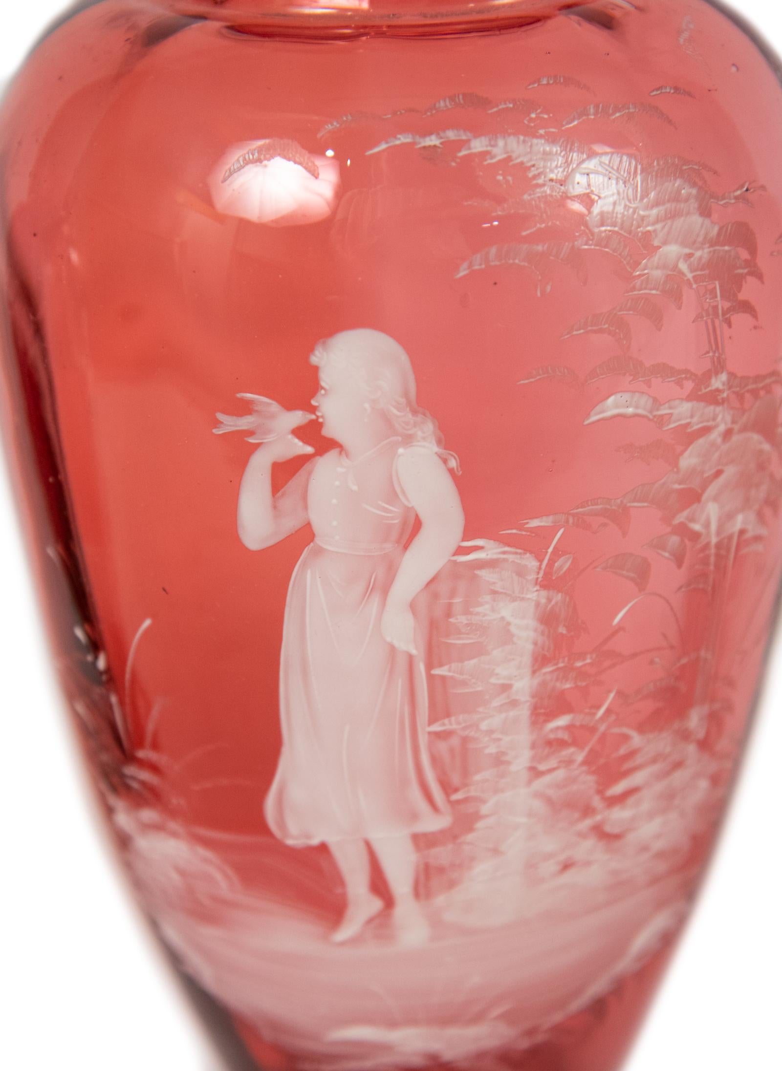 A Mary Gregory cranberry enameled vase. Finely enameled depicting a young girl kissing a bird.