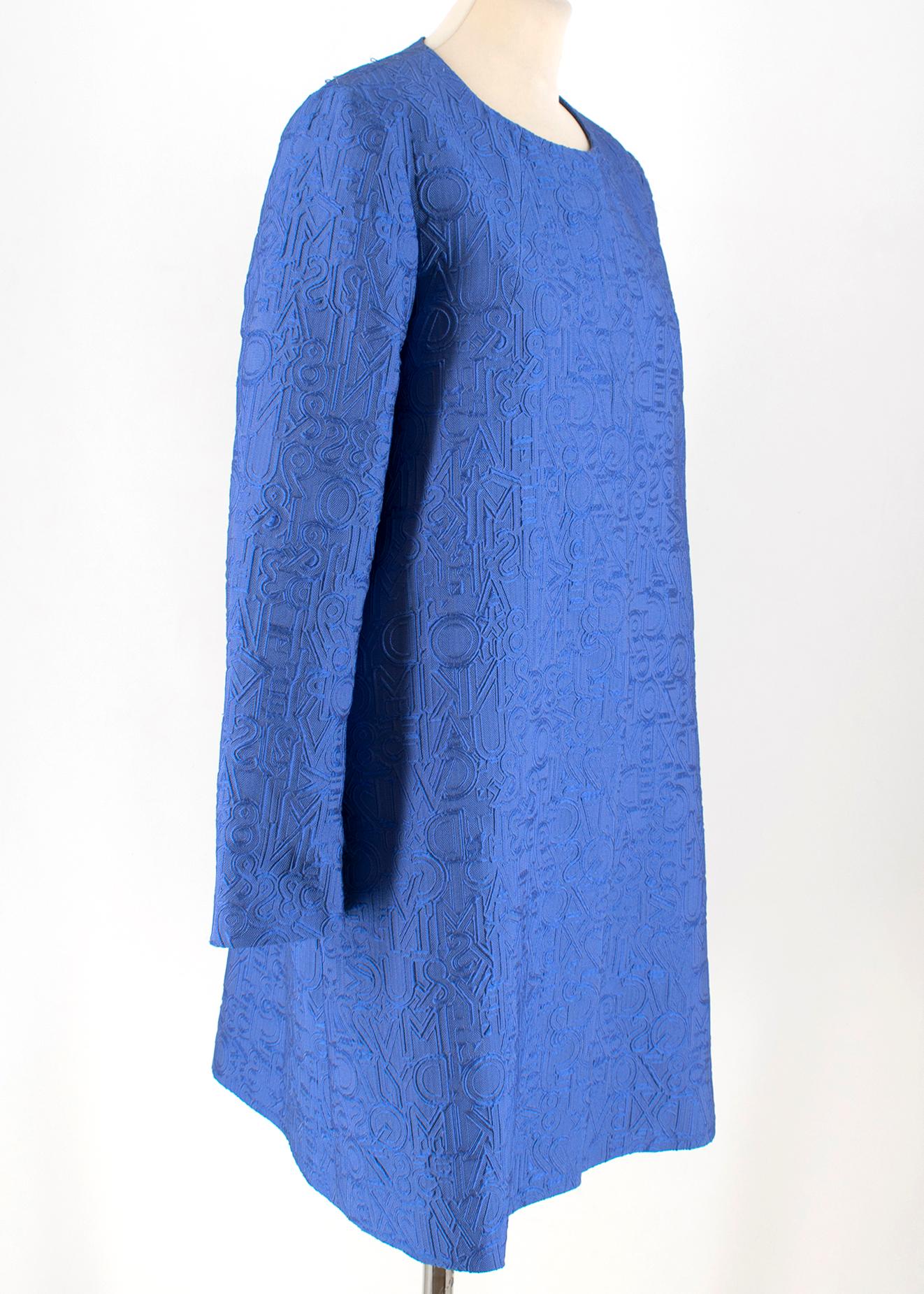 Mary Katrantzou Blue Brocade Twill Coat 

- Blue light coat 
- Textured fabric with letter design
- Grey silk lining
- Round neck
- Hidden push button fastening
Please note, these items are pre-owned and may show some signs of storage, even when