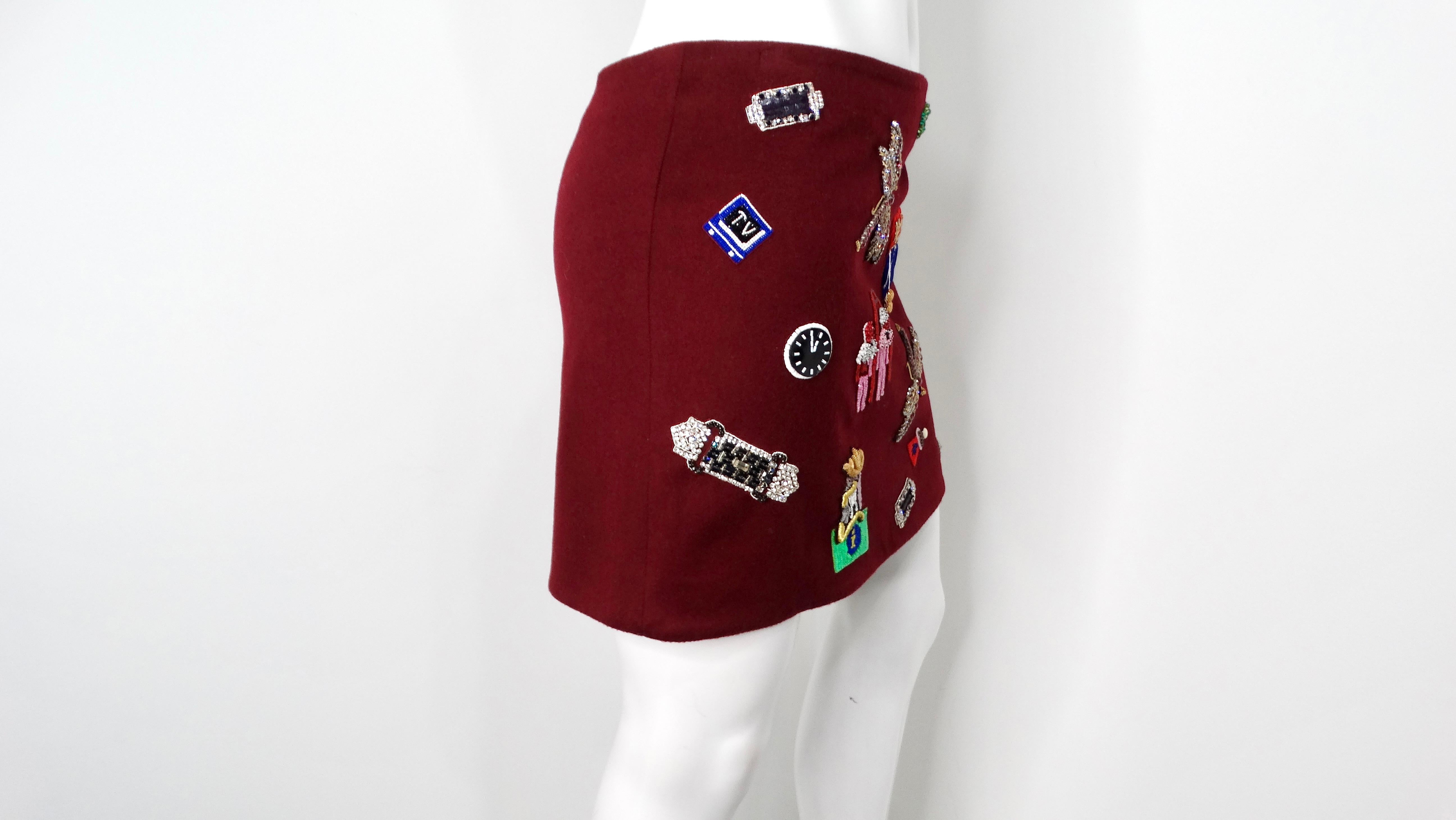The Mary Katrantzou Burgundy Wool Patch Mini Skirt is a striking and playful addition to any fashion-forward wardrobe. Crafted from luxe burgundy wool, this mini skirt features an array of eclectic patches on the front, showcasing whimsical motifs