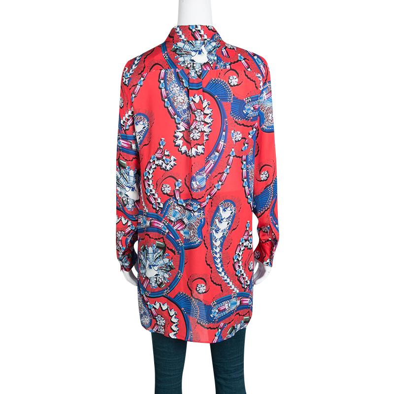This red-colored, jewel printed Croft tunic from the Mary Katrantzou is a gorgeous piece for your casual dos. It features full sleeves with buttoned cuffs, a stylishly collared neck, and slim fitting. Crafted with silk, the outfit, which was a part